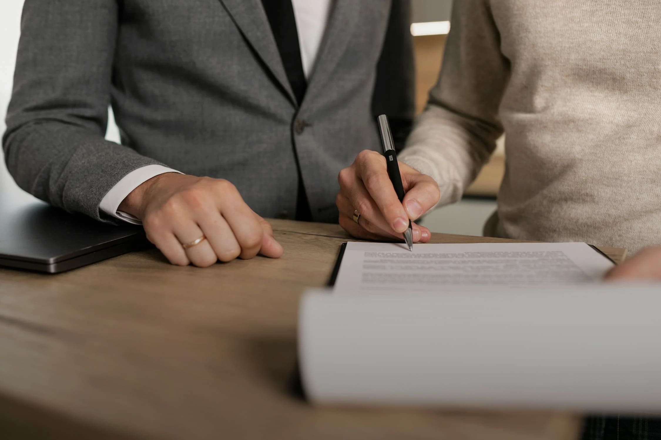 Close-up of people signing legal documents