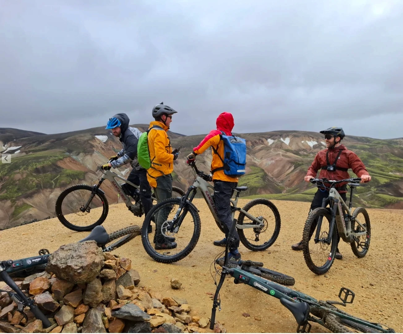 four men in colorful jackets take a break with their santa cruz vala bikes in Landmannalaugar Iceland