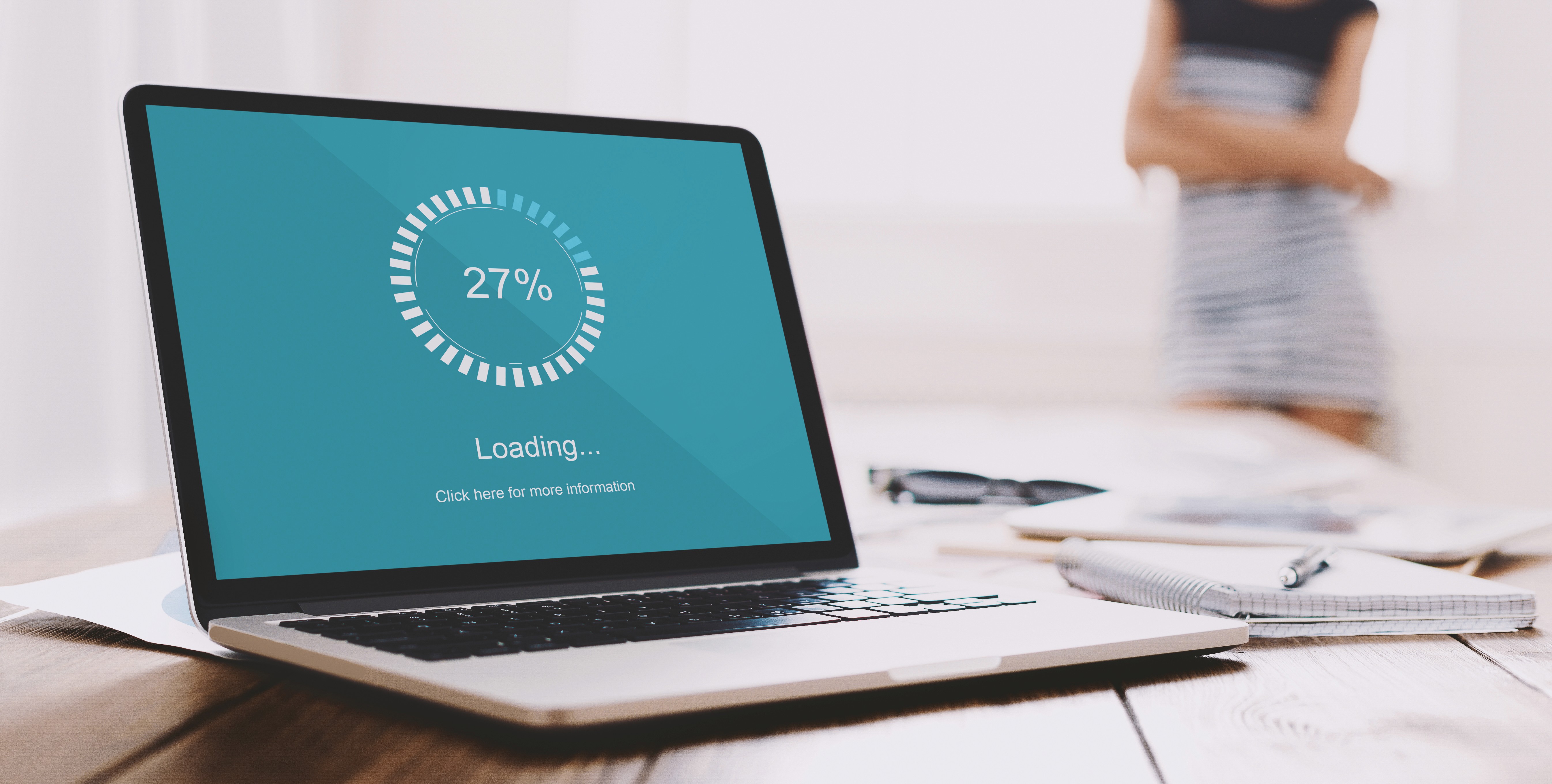 Laptop screen displaying a 27% loading bar, representing slow website performance and the impact of loading time on user experience.