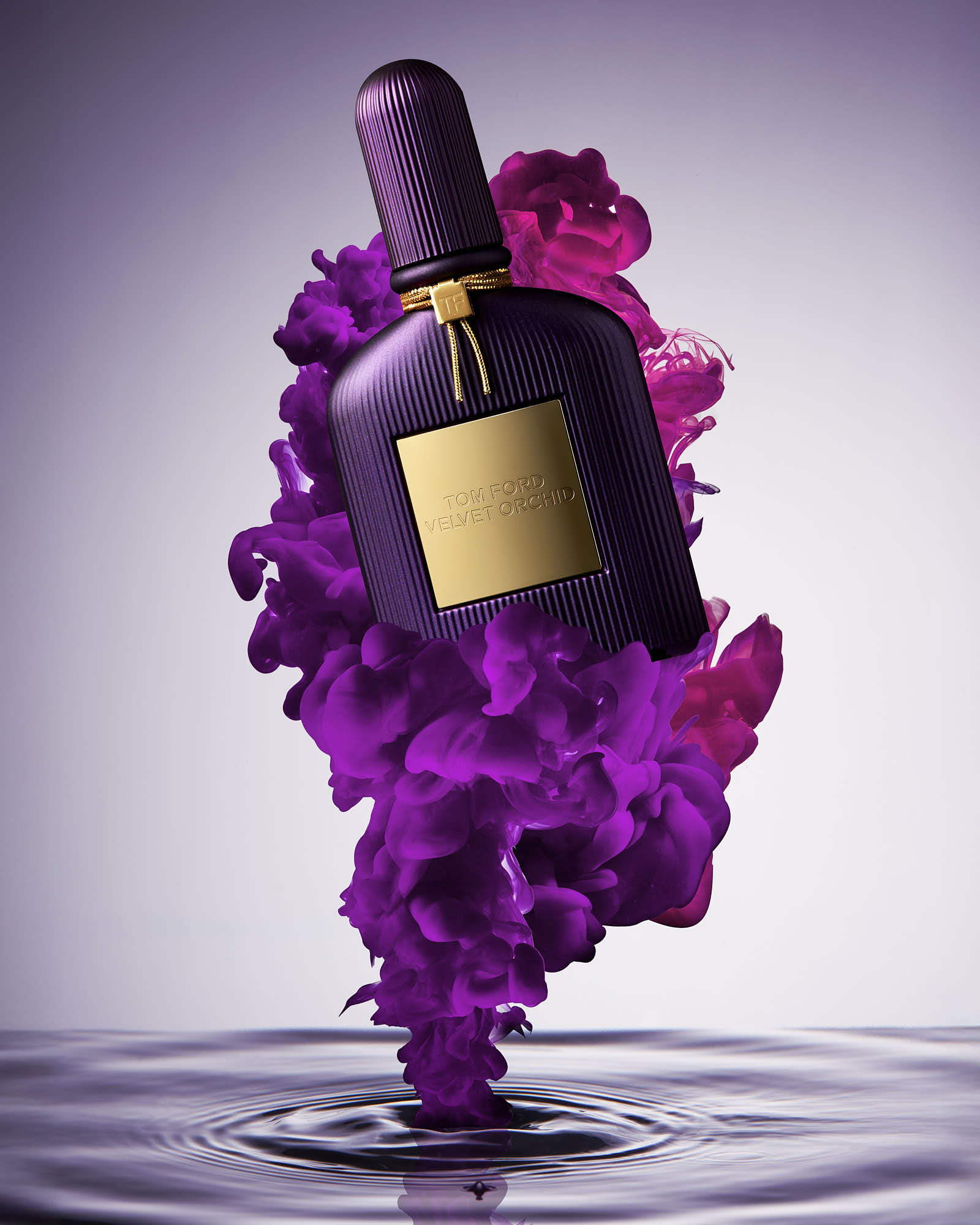 A bottle of fragance is surrounded by swirling purple smoke against a soft, illuminated background.