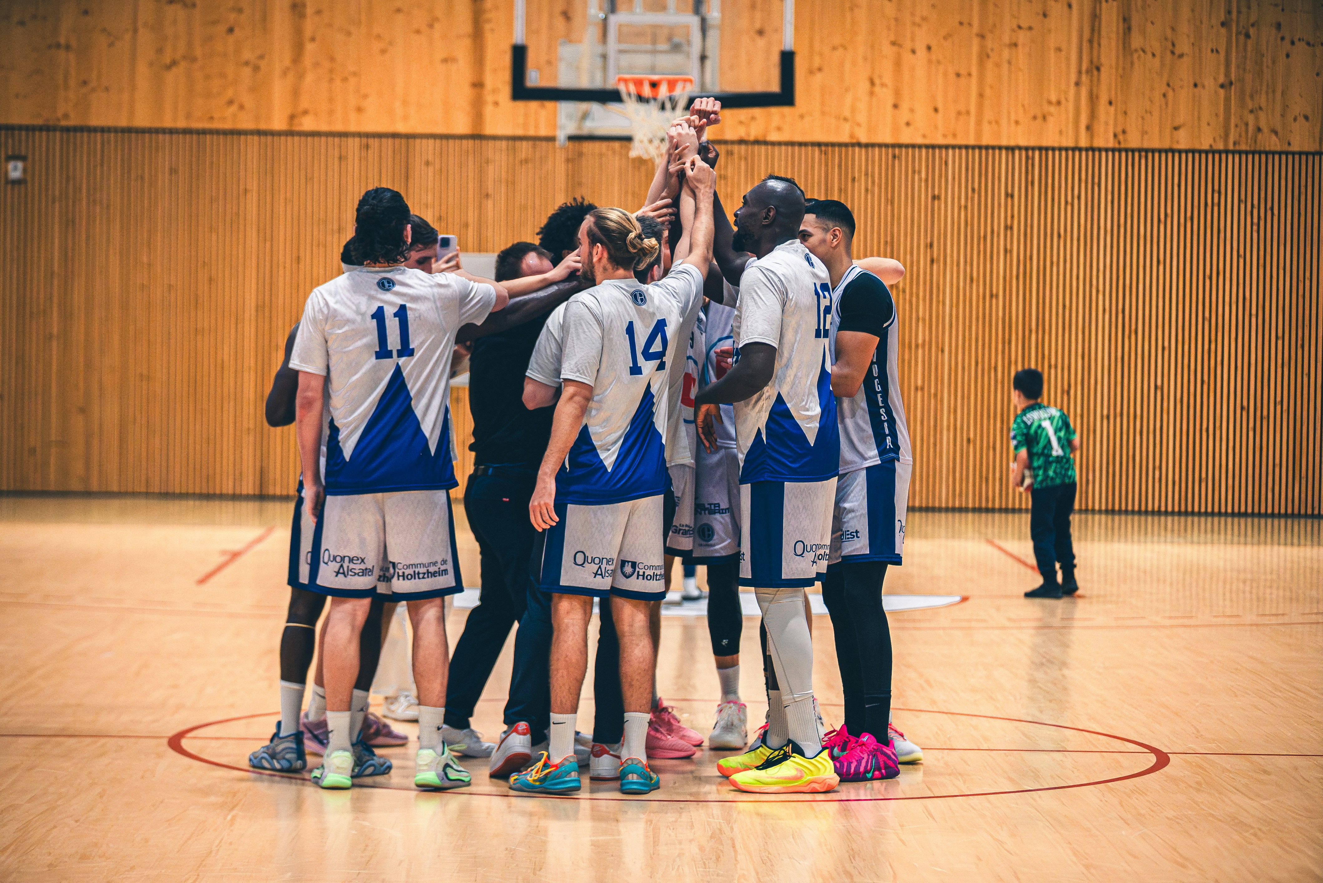 Basketball team huddles together on court