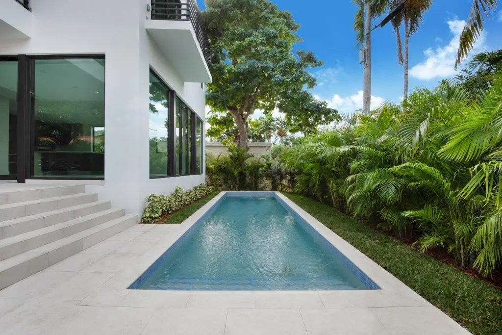 Private lap pool with tropical landscaping in modern residential architecture project in Miami Beach by Atelier International LLC