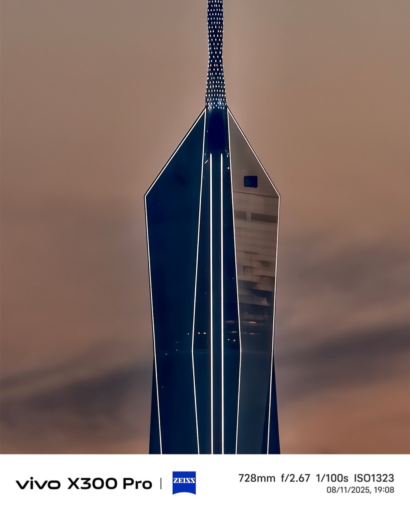 A close-up shot of the vivo X300 Pro showcasing its sleek design, featuring a tall, illuminated structure against a dusky sky.