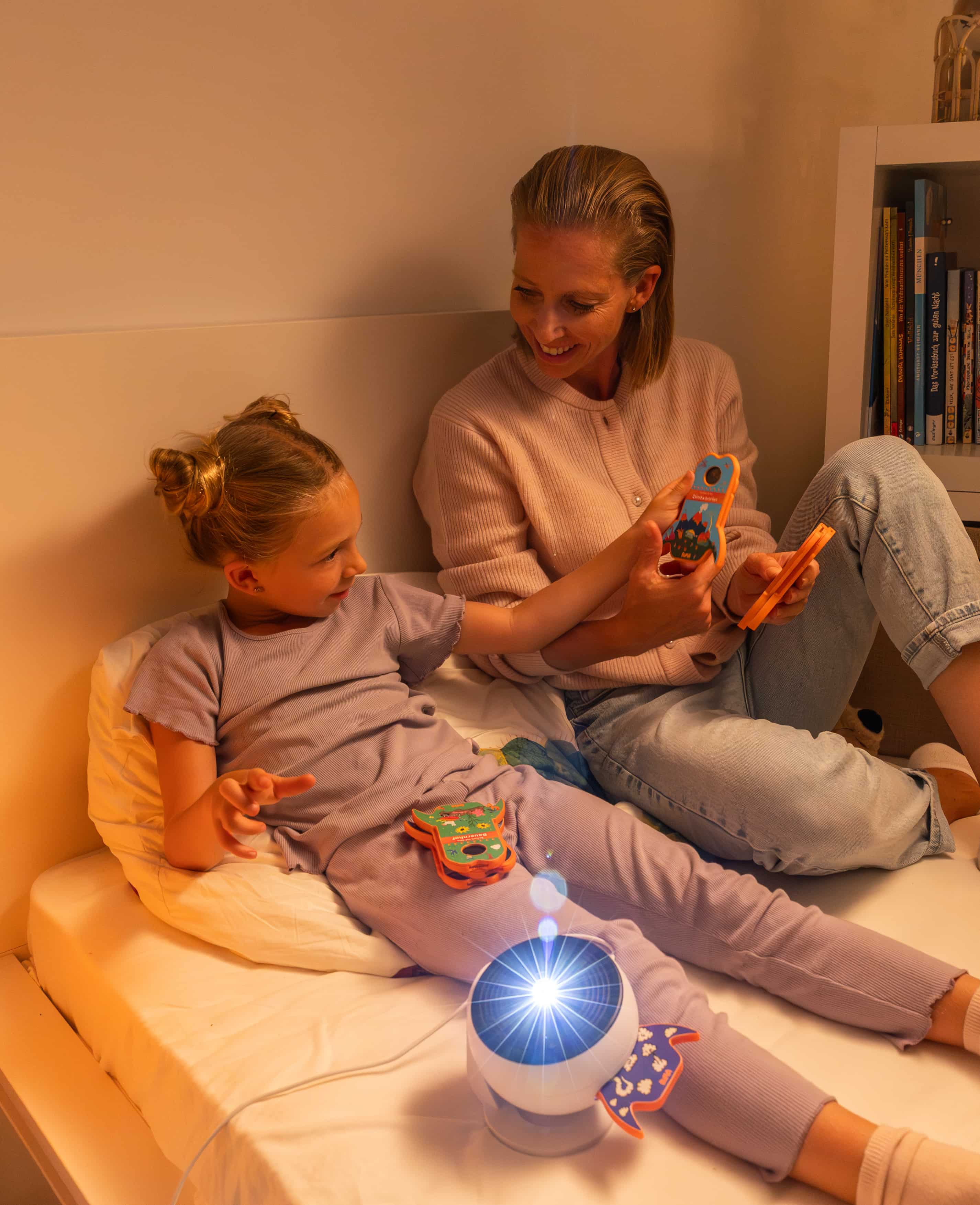 Mutter und Tochter schauen sich die BiMA Raketen an, während der BiMA Projektor an ist.