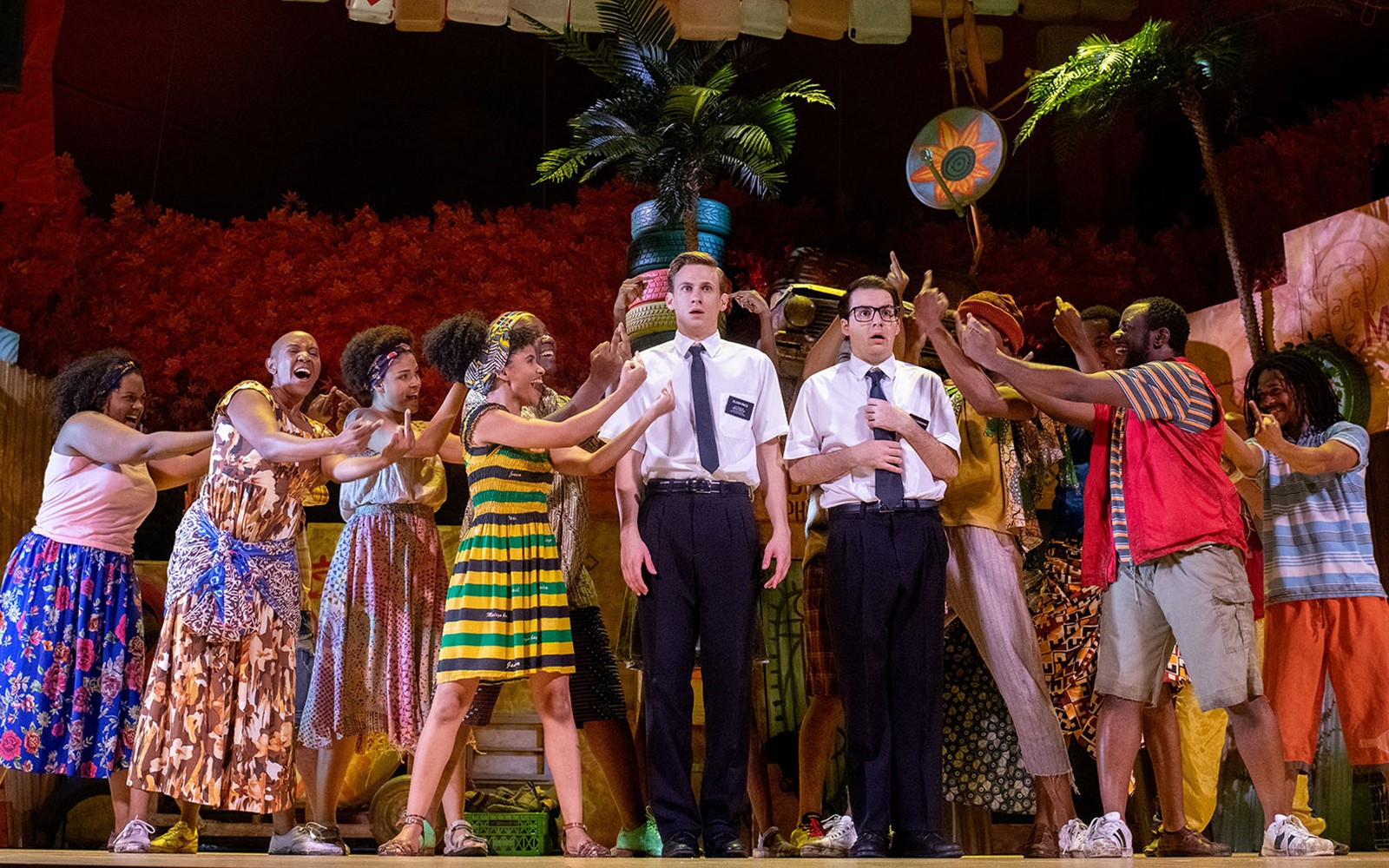 Performers on stage during "The Book of Mormon" musical scene with vibrant costumes.