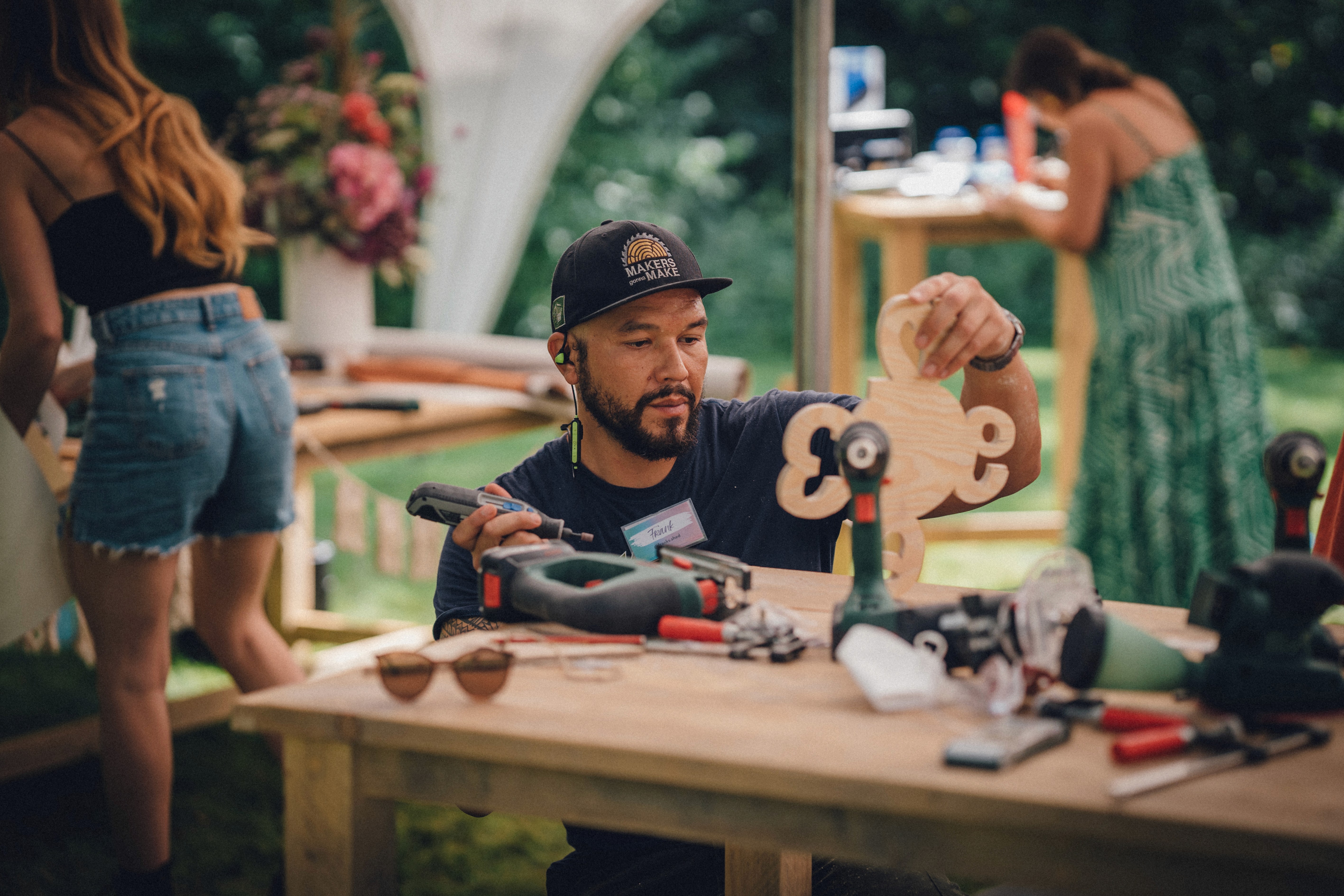 Ein Creator arbeitet in einem Workshop mit Bosch an seinem DIY-Projekt, einer Uhr aus Holz.