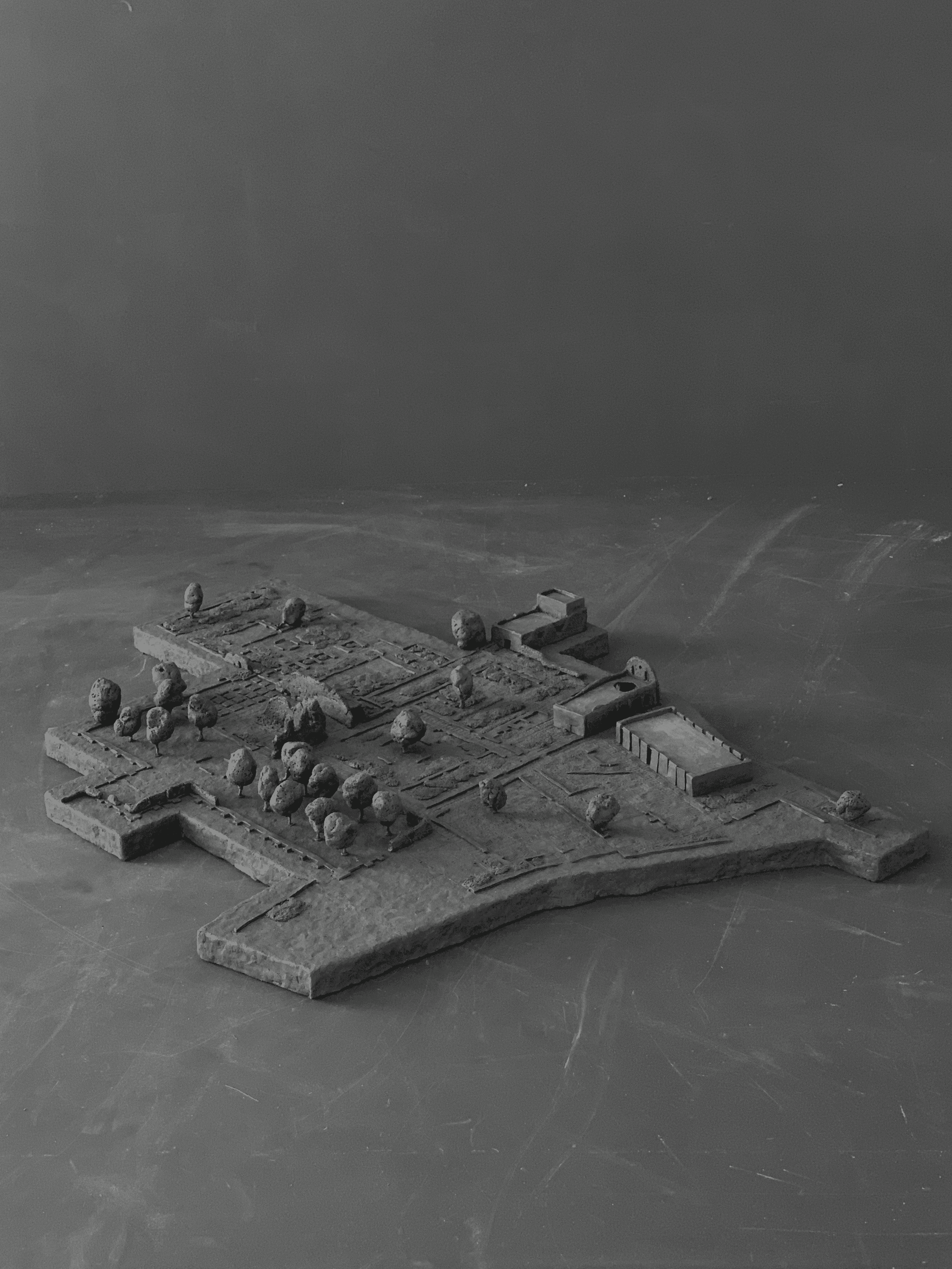 A spacious indoor café with wooden floors, large windows, plants, and a mix of seating areas and workspace.