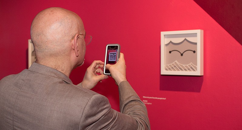 Steve taking a picture of frame on the wall