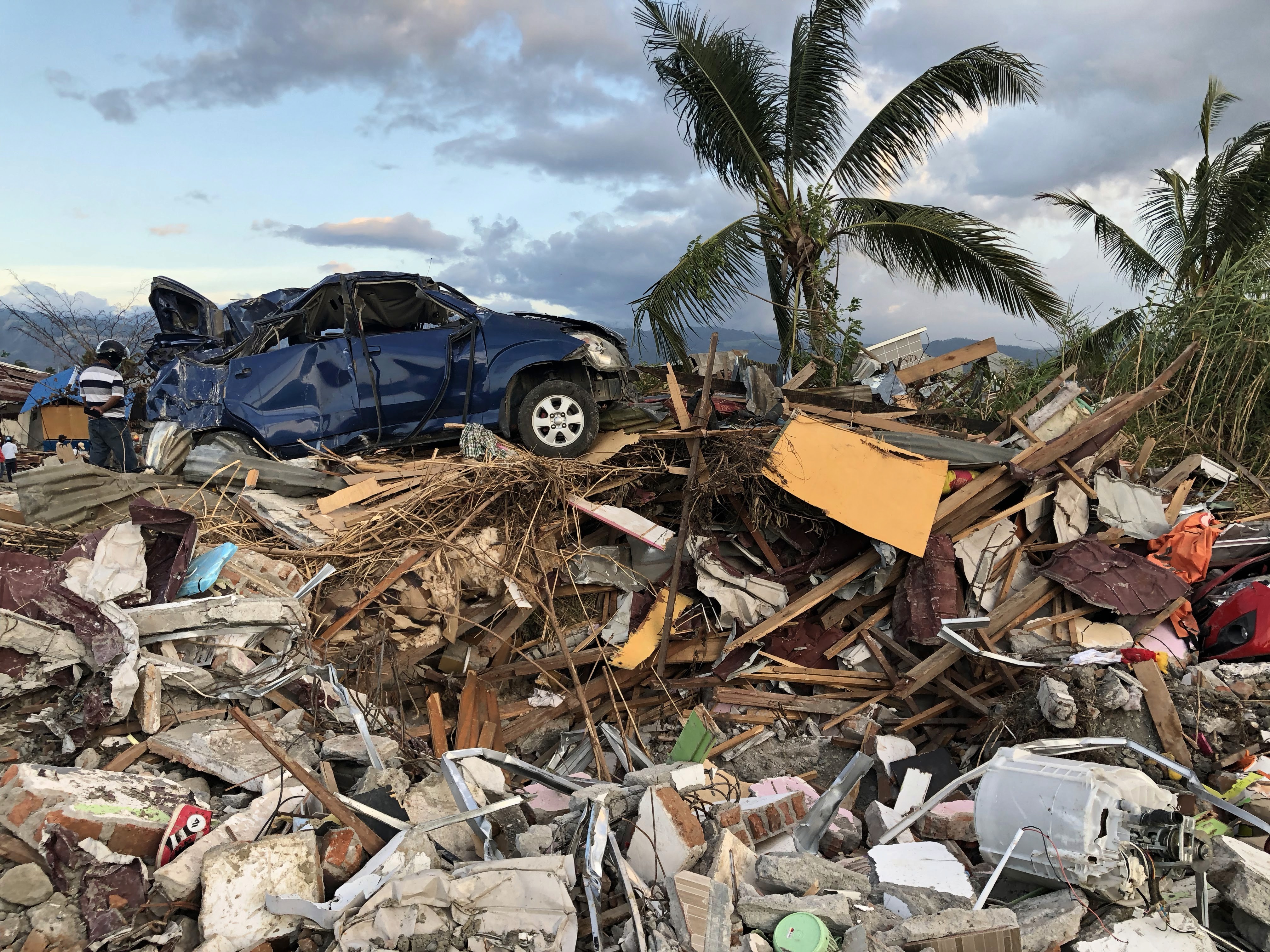 man in black polo shirt wearing white mask holding black camera