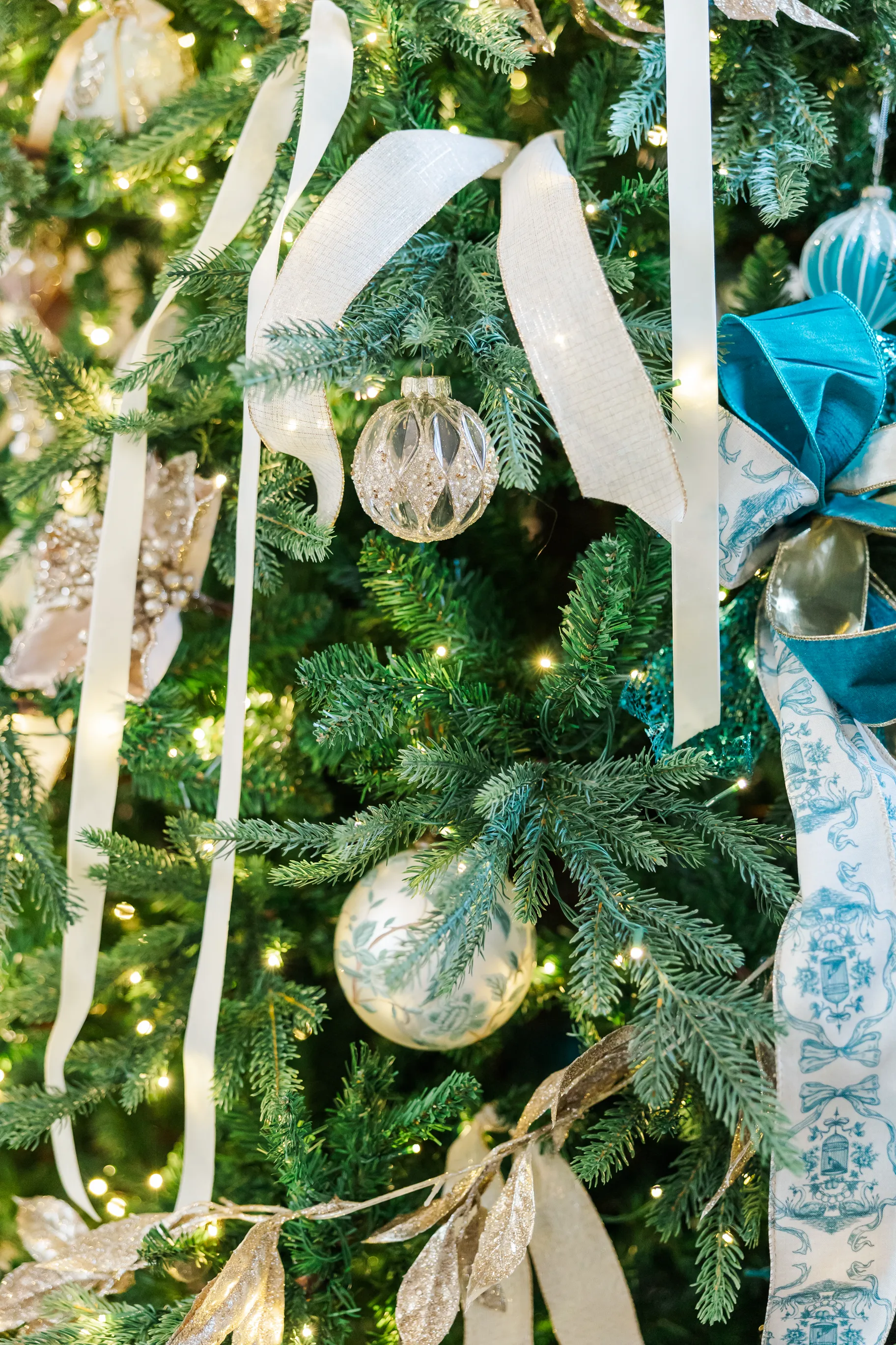 Luxury table setting by Sarah Overall Events with pink embroidered napkins, gold-rimmed plates, floral arrangements, and personalized menus in Shreveport.