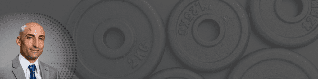 Portrait of Angelo Gingerelli alongside several black weight plates on a dark background, symbolizing strength and conditioning.