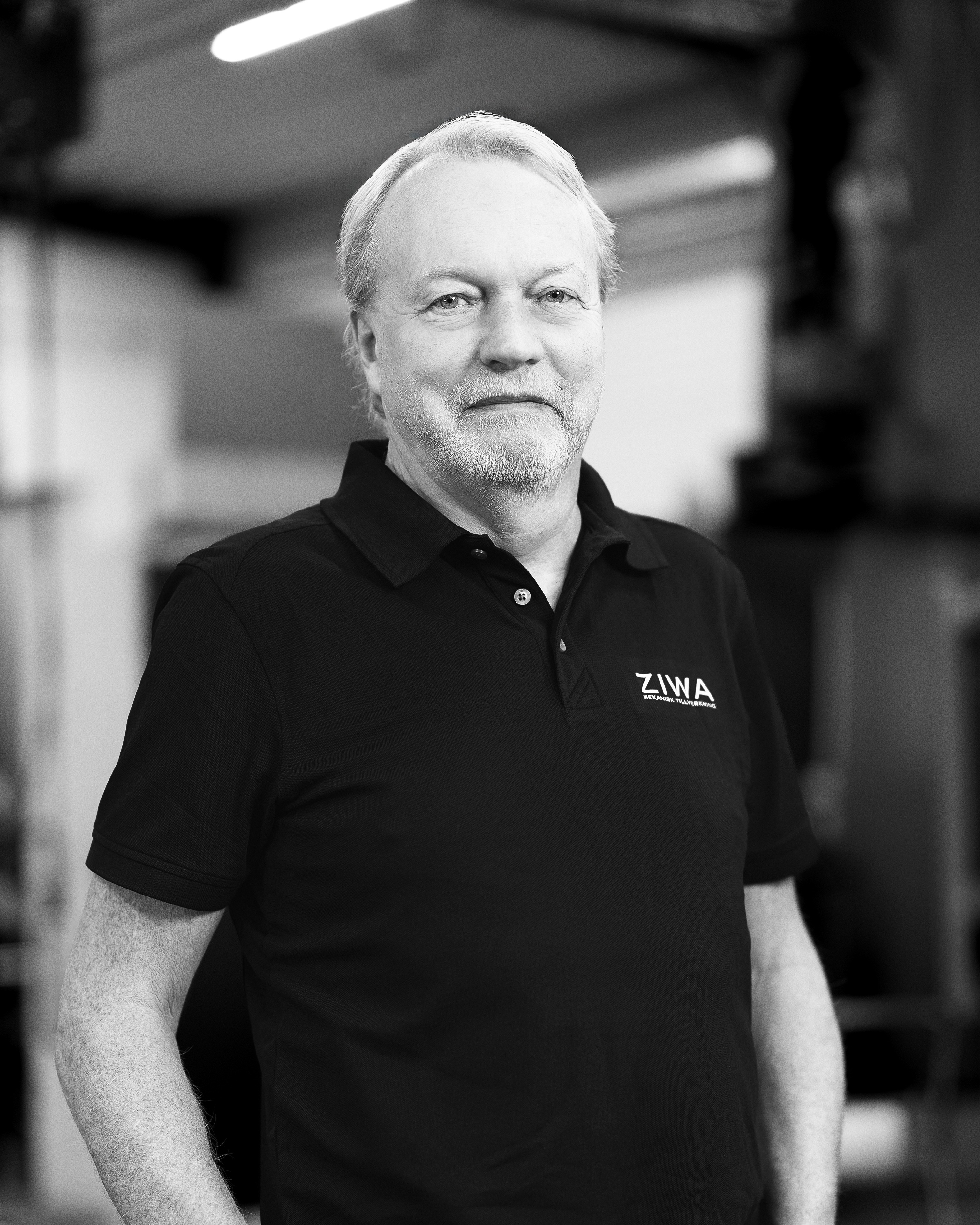 Portrait of a man with blue eyes and a beard, wearing a denim shirt