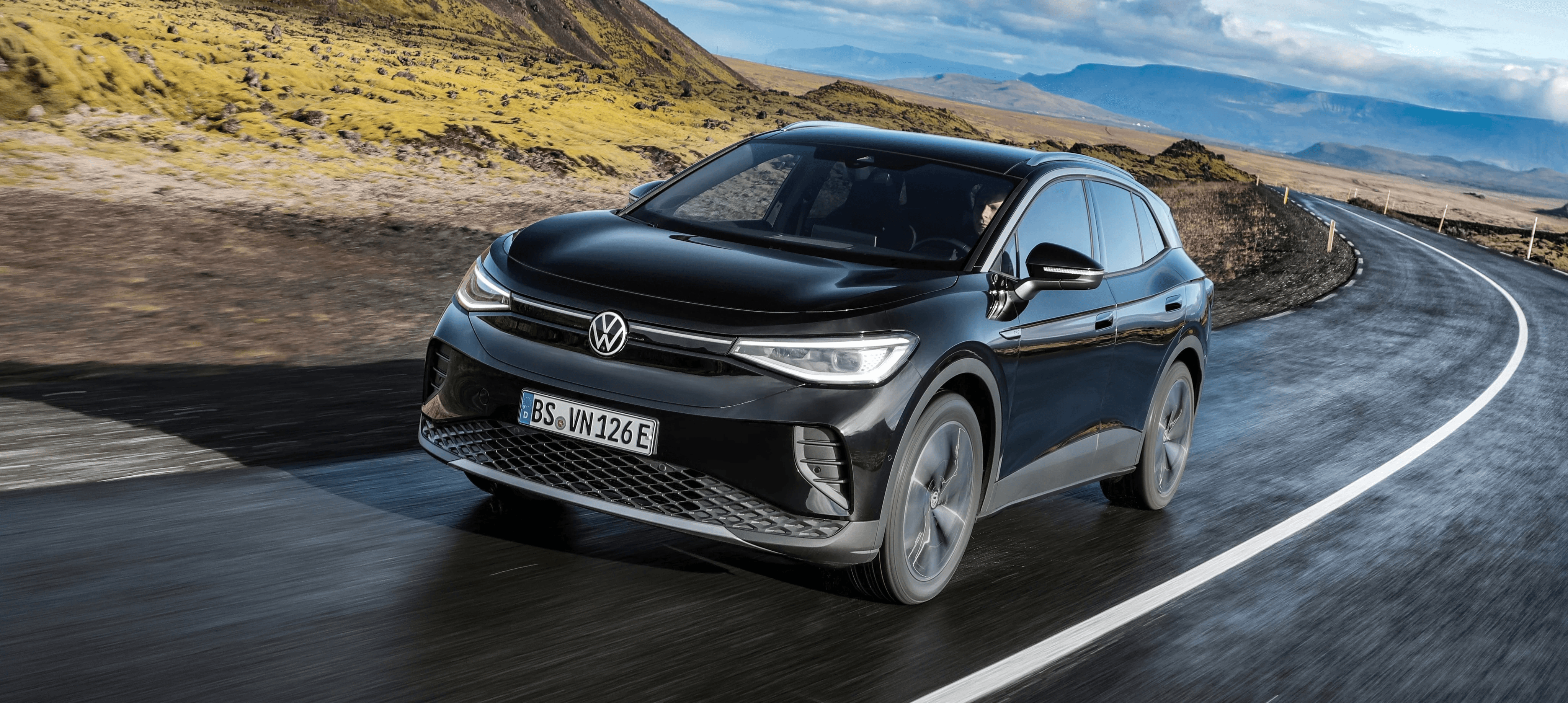Volkswagen ID.5 noire sur route sinueuse, SUV coupé électrique en conduite dans un décor naturel spectaculaire
