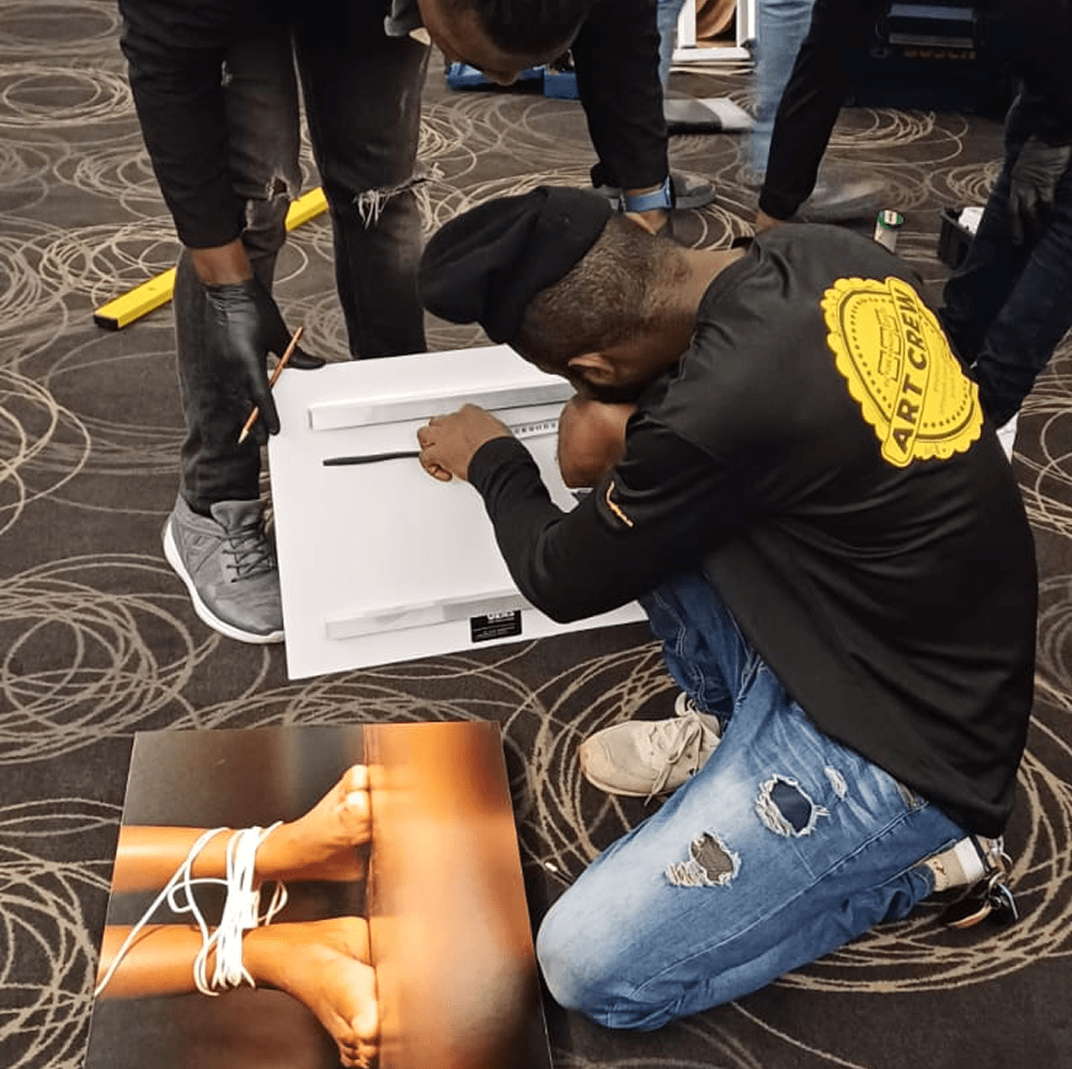 two people facing to the right, standing in front of two arworks