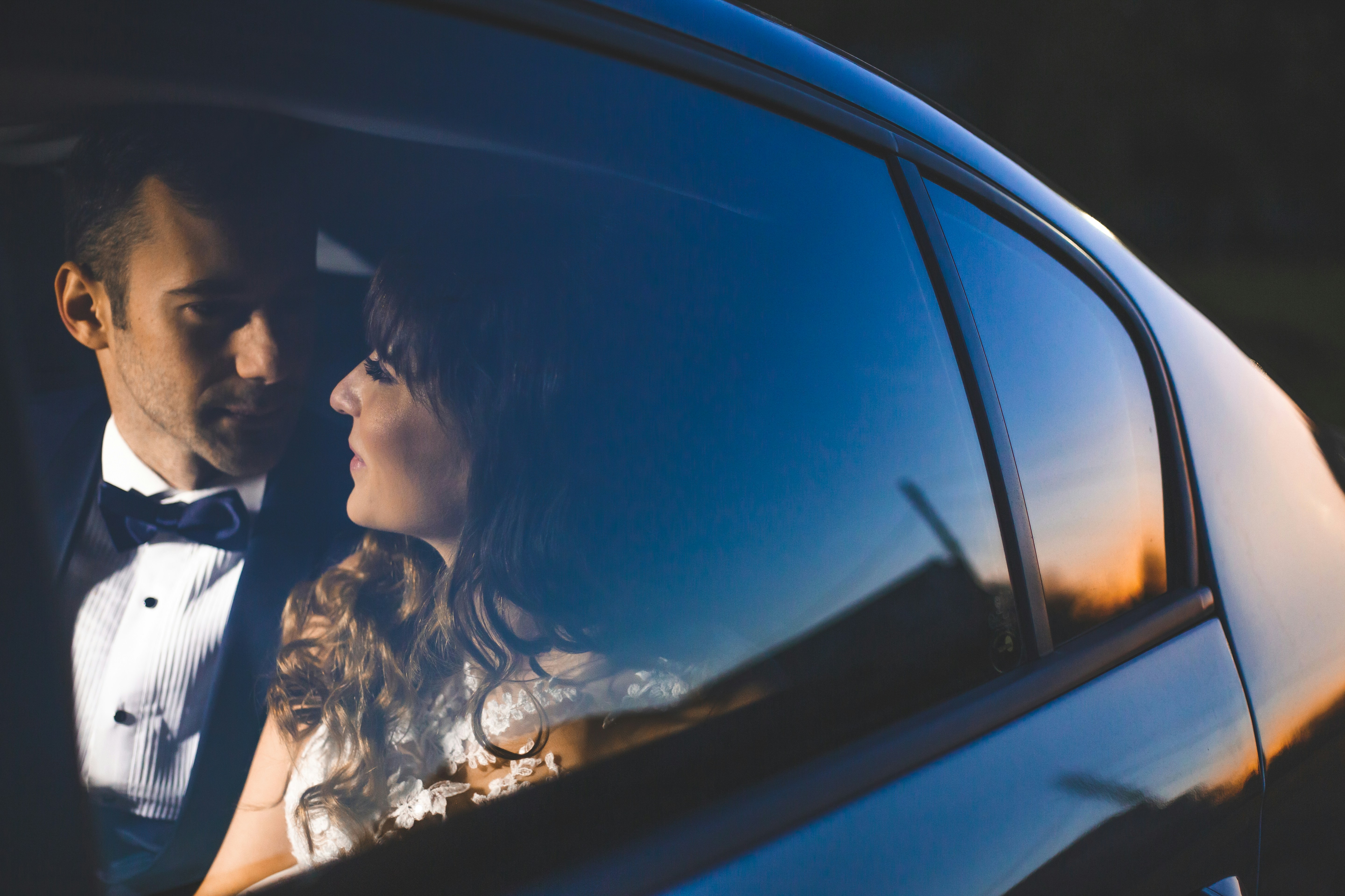a man and a woman in a car in wedding attire