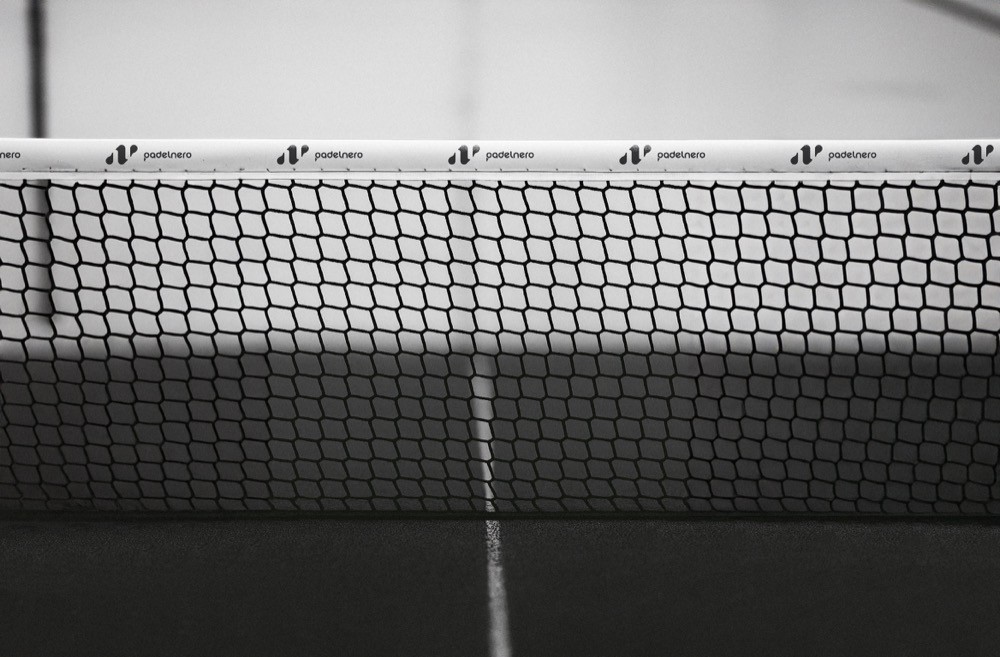 „Detailaufnahme eines Padelnetzes mit Padelnero-Logo – klare Linien, Kontrast und Design im Mittelpunkt des schwarzen Courts.