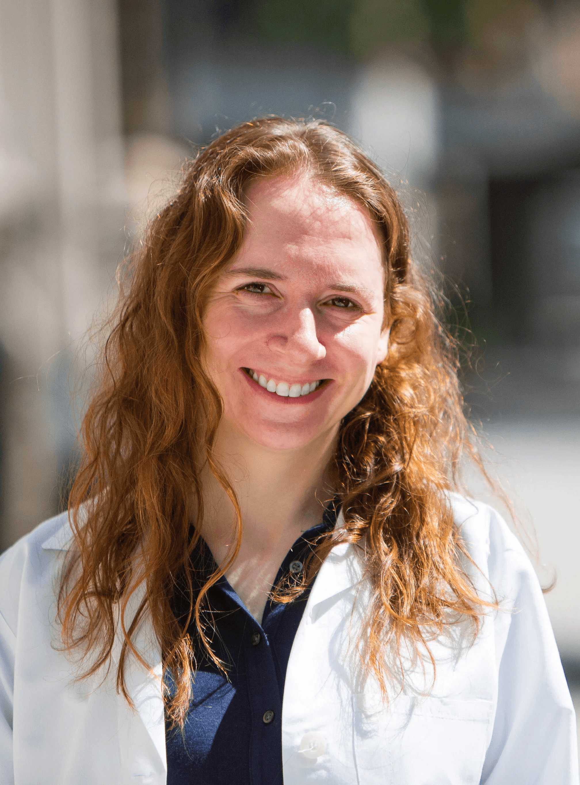Portrait of a woman with long red hair gently touching her face, looking into the camera