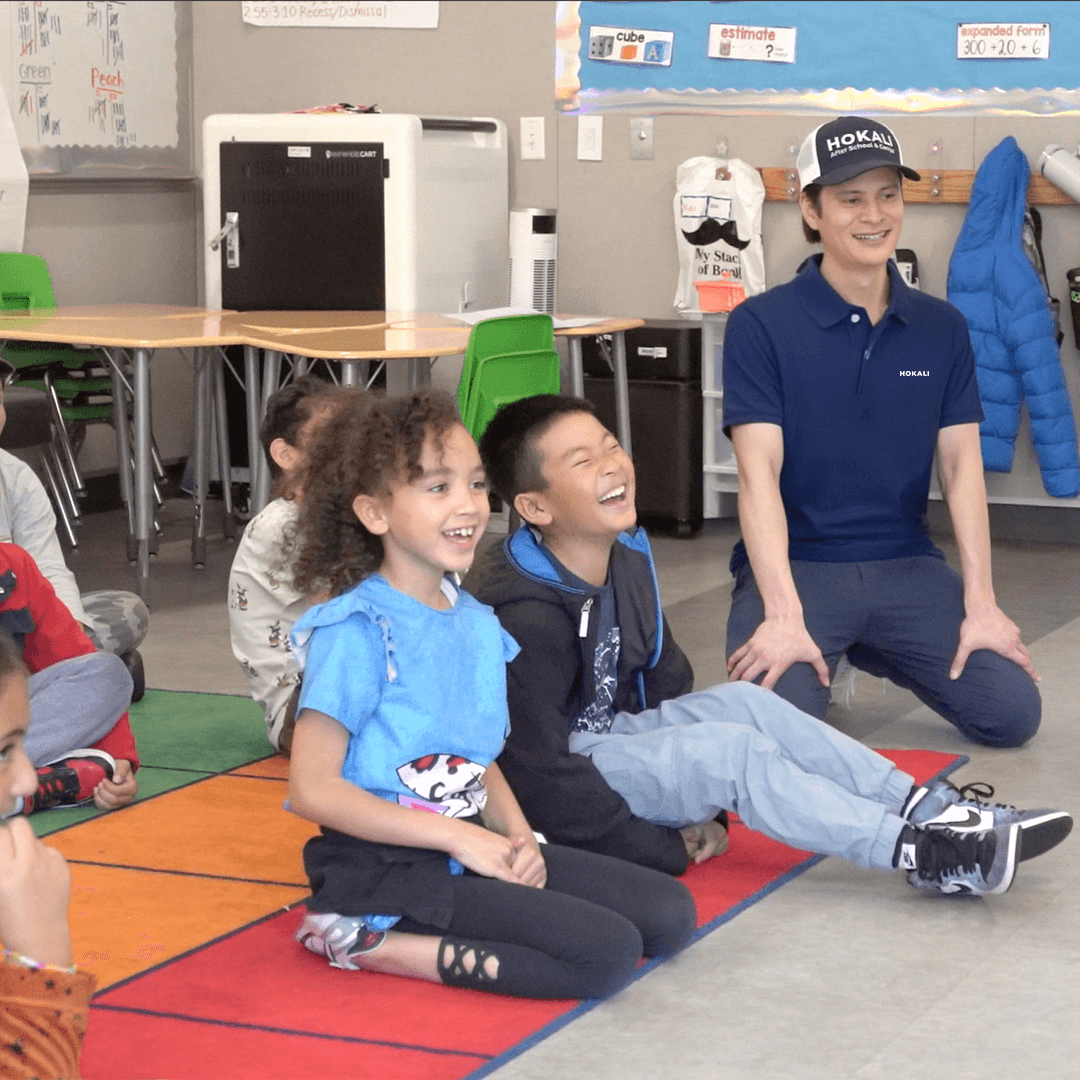 Kids enjoying an interactive learning activity with a HOKALI summer camp educator indoors
