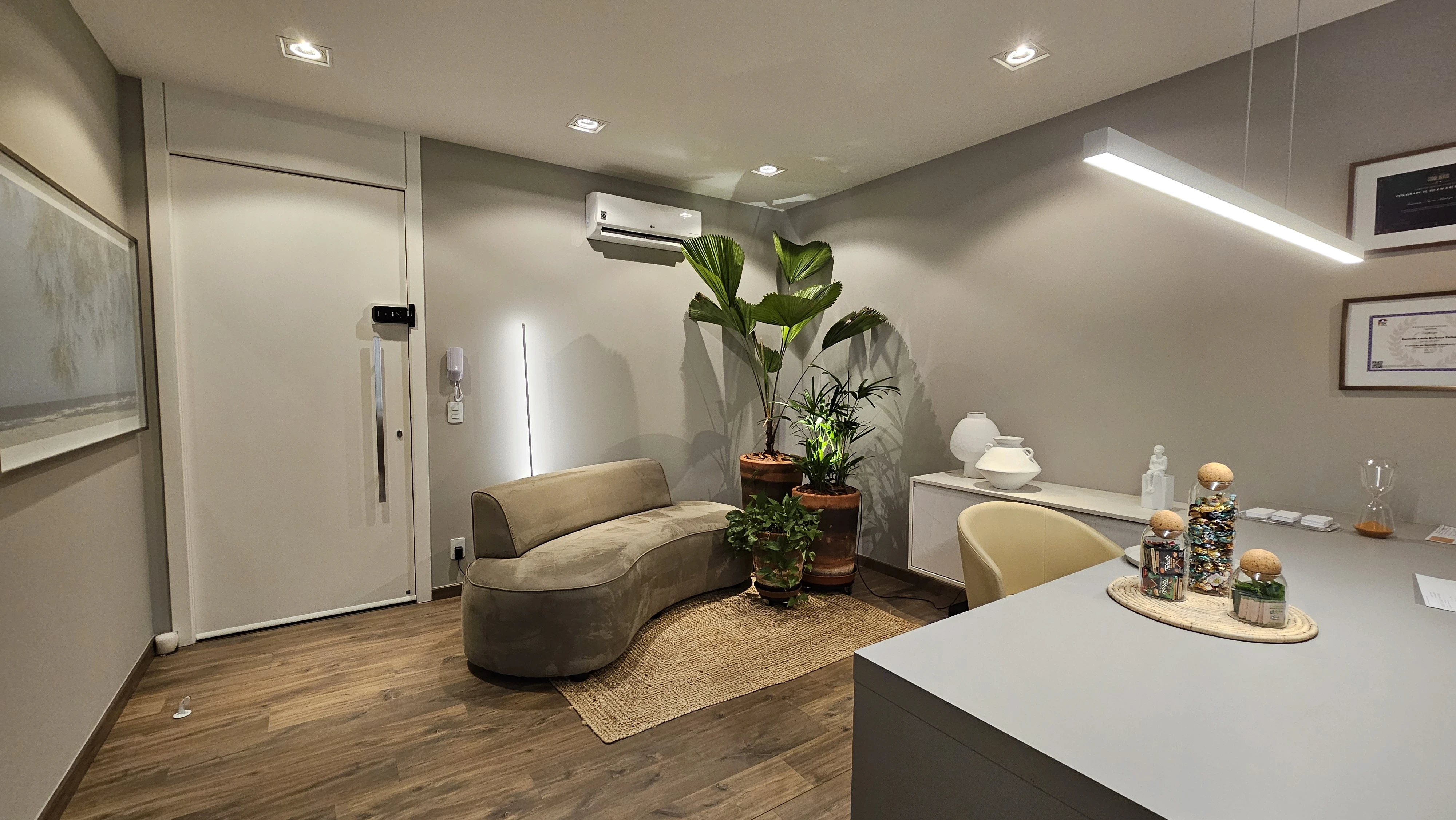 Group of hikers walking through a mountain meadow surrounded by pine trees and misty peaks.