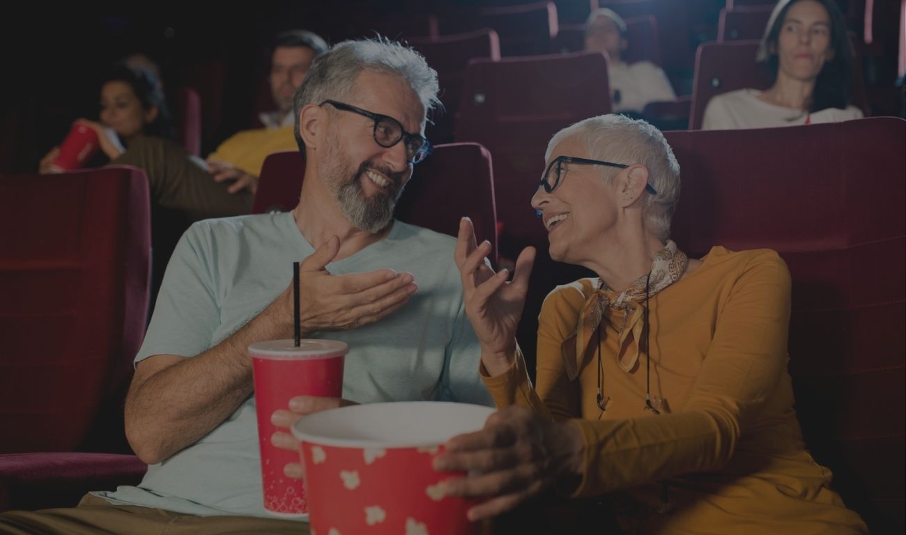 Senior couple watching the movie at the cinema and enjoying.