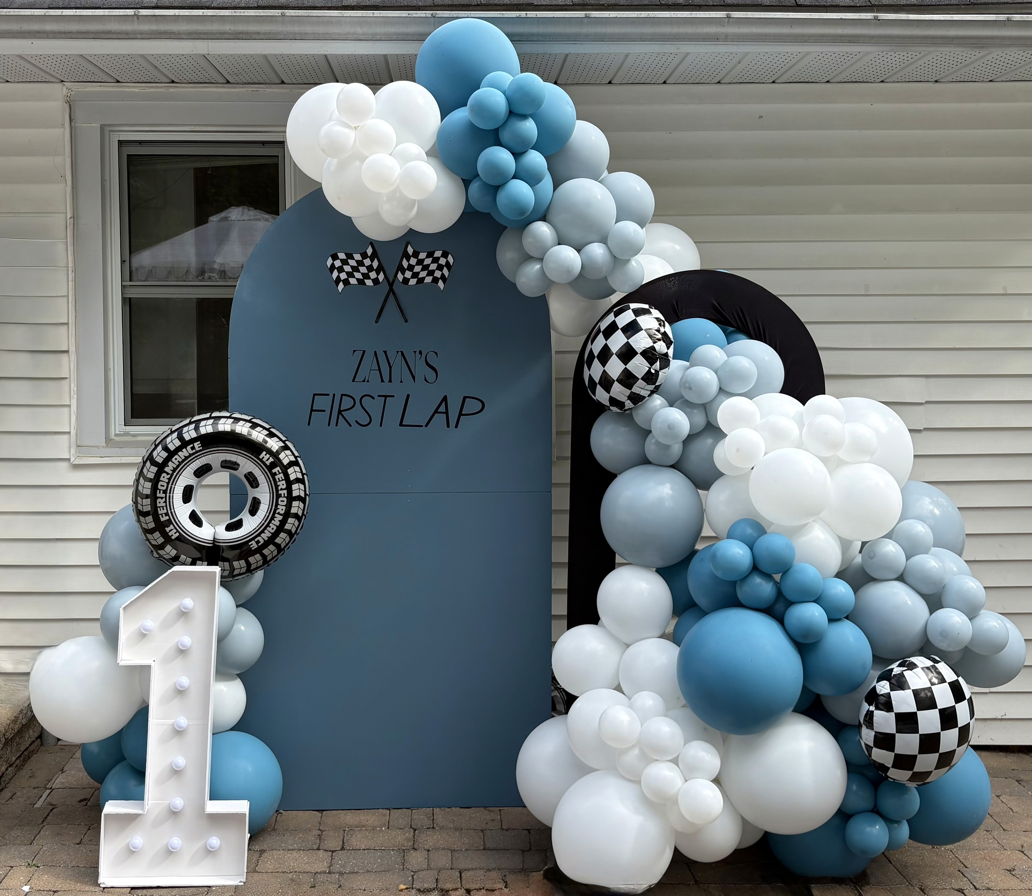 Nude, Brown and white balloon arch in a office. There is a cake stand and a dusty pink arch behind it.