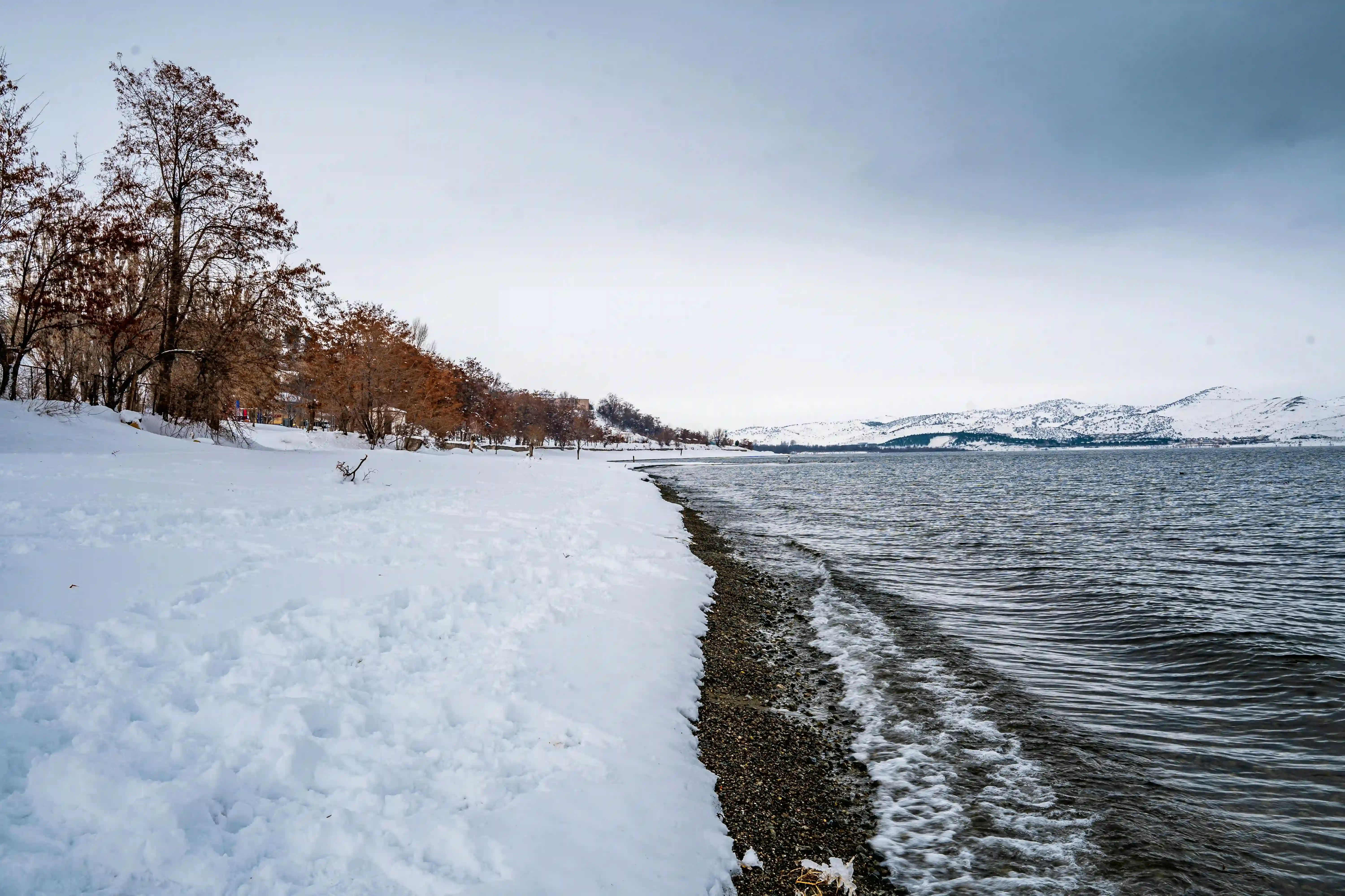 Eine schneebedeckte Küstenansicht und Berge