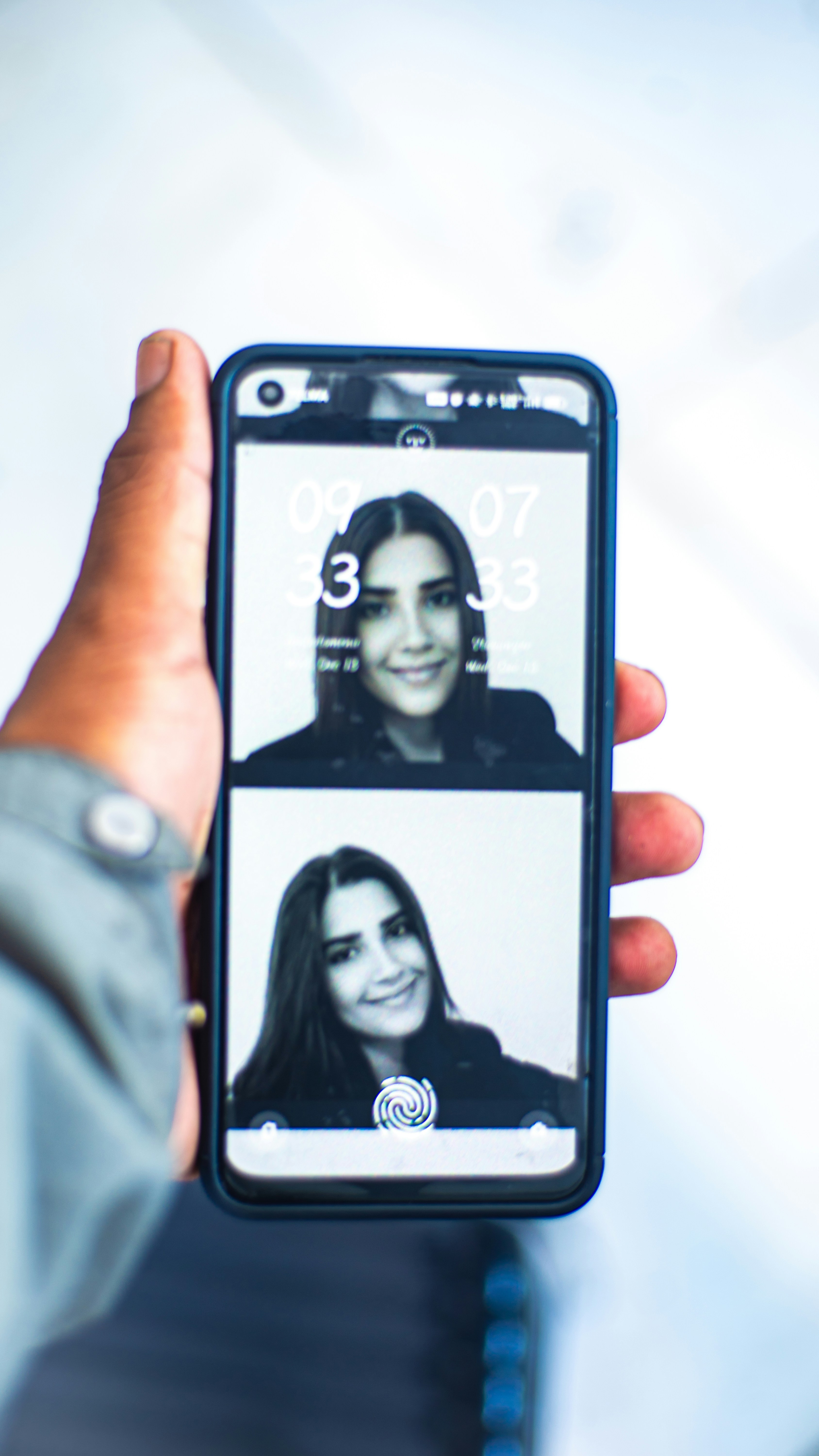 a person holding up a cell phone with two pictures on it