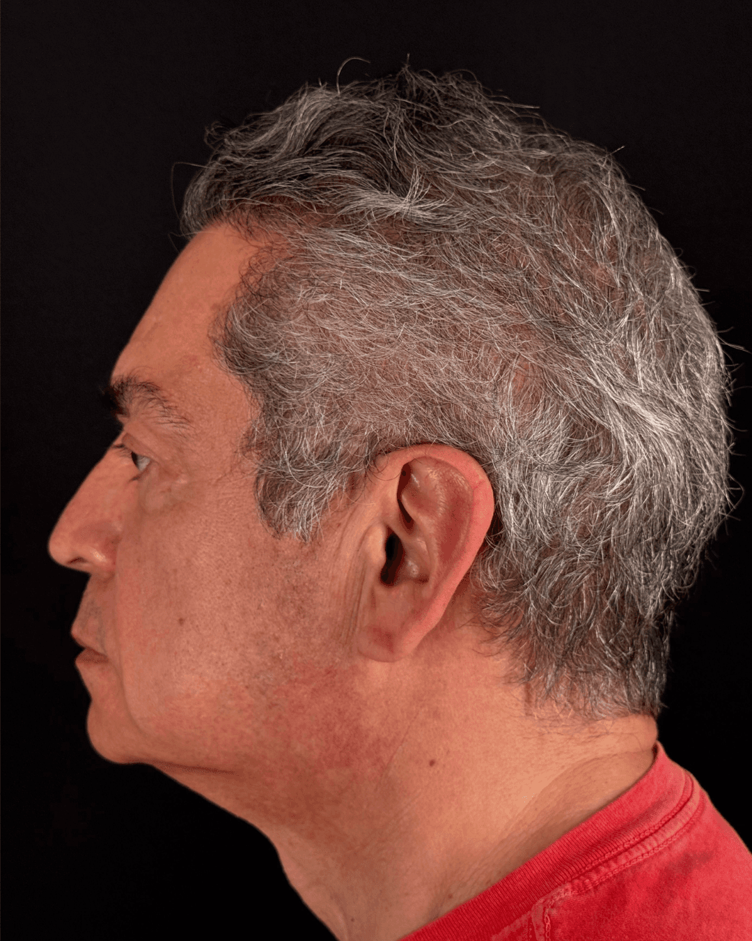 Woman in orange shirt looking up at blue sky
