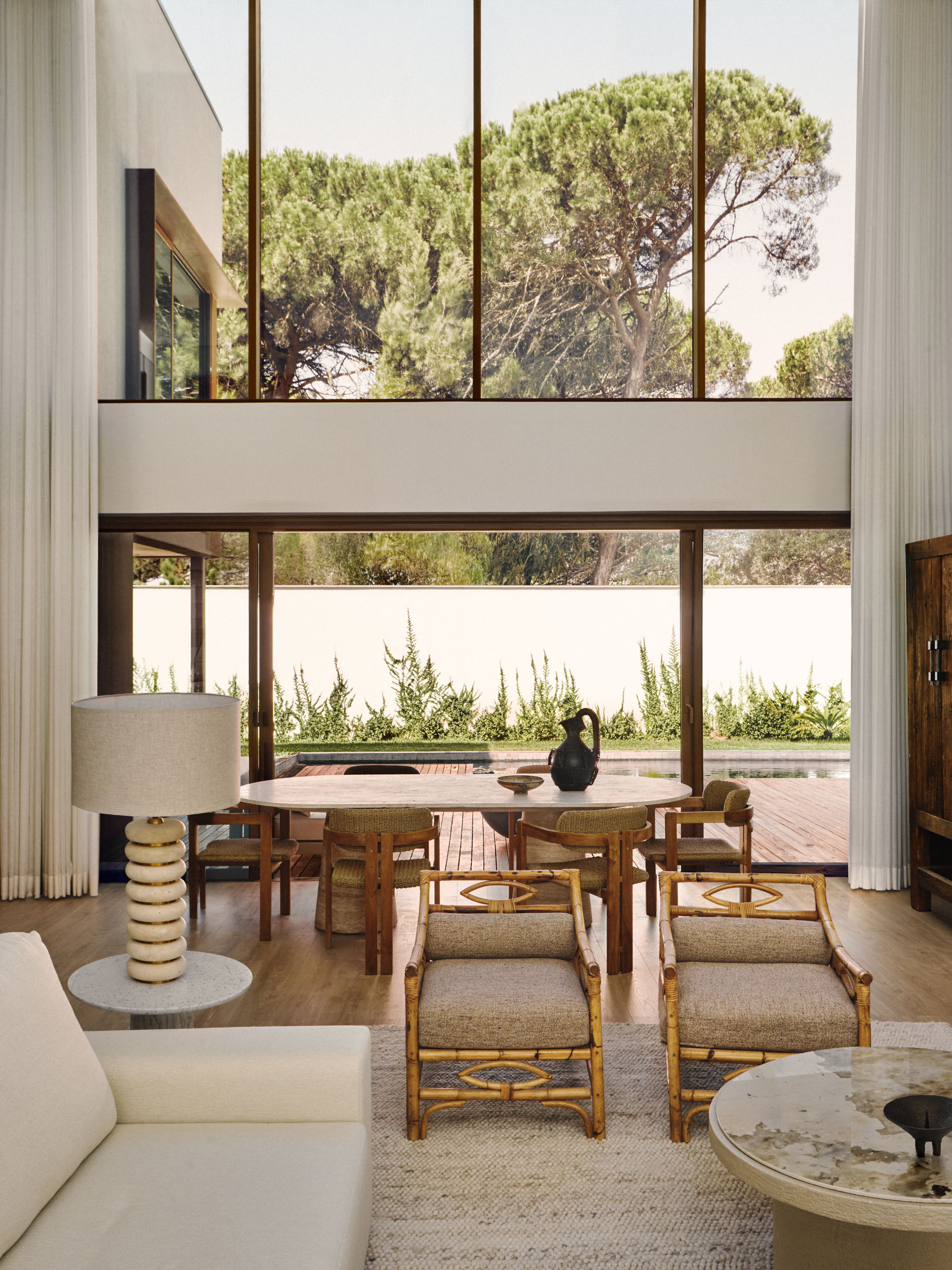 Dining area with large windows overlooking the garden in an Estoril house by Raúl Martins