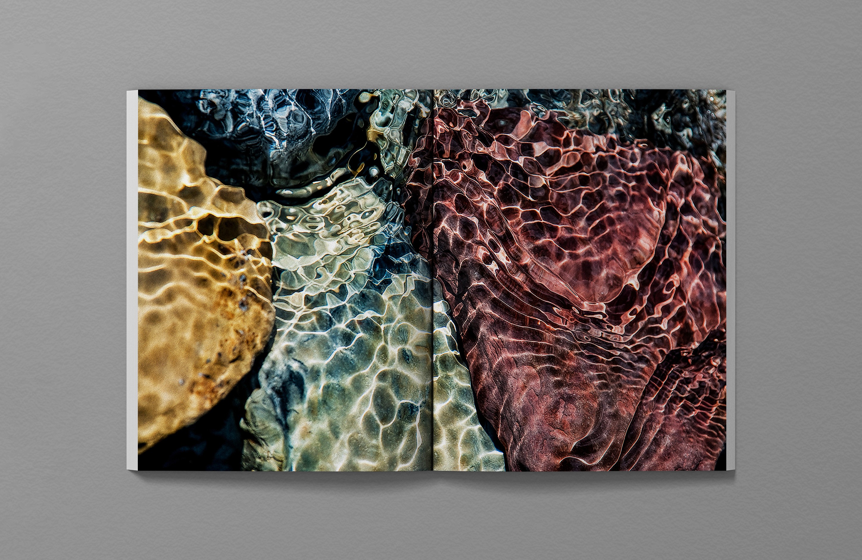 Hugo Boss SS26 Elevated Calm editorial, macro photograph of submerged rocks under water showing refracted light in gold, teal, burgundy, visual reference for Submerged Luminescence print