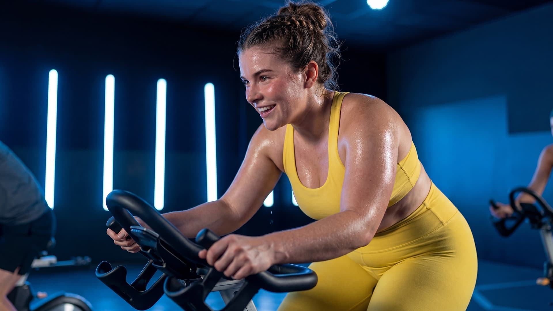 Frau trainiert motiviert auf dem Spinning-Bike beim XTRA Cycle Kurs im Fitnessstudio