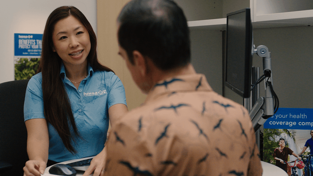 Healthcare worker speaking with patient at front desk