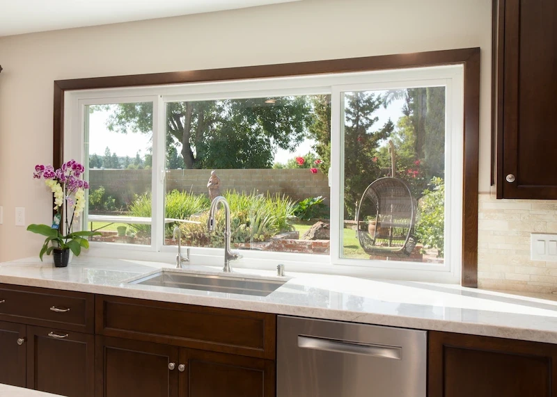 Kitchen sink with quartz countertop and large window overlooking the garden in Orange Interior Remodel.