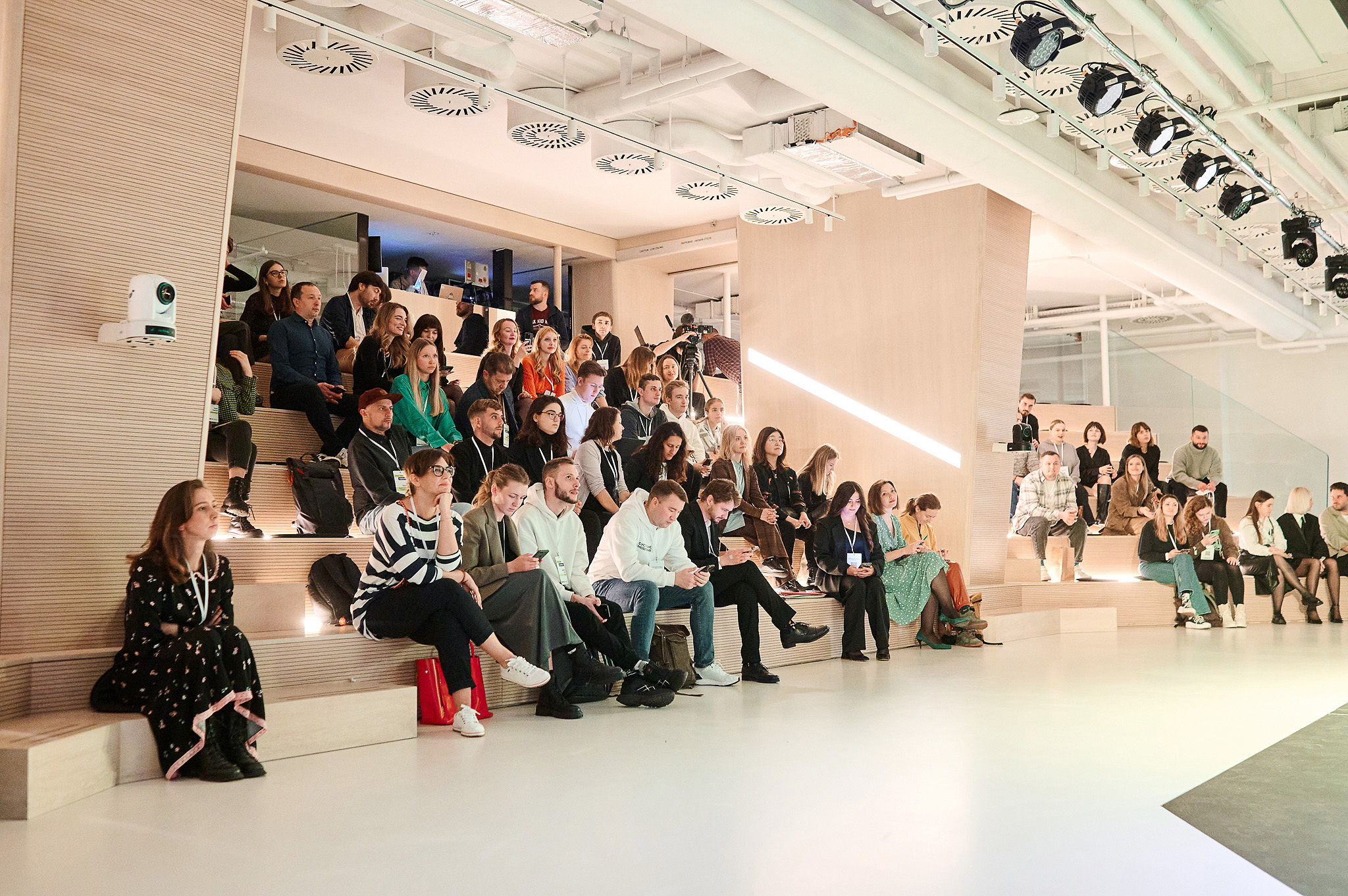 A speaker presenting at an AI conference in front of an audience, discussing real-world approaches to building AI products.