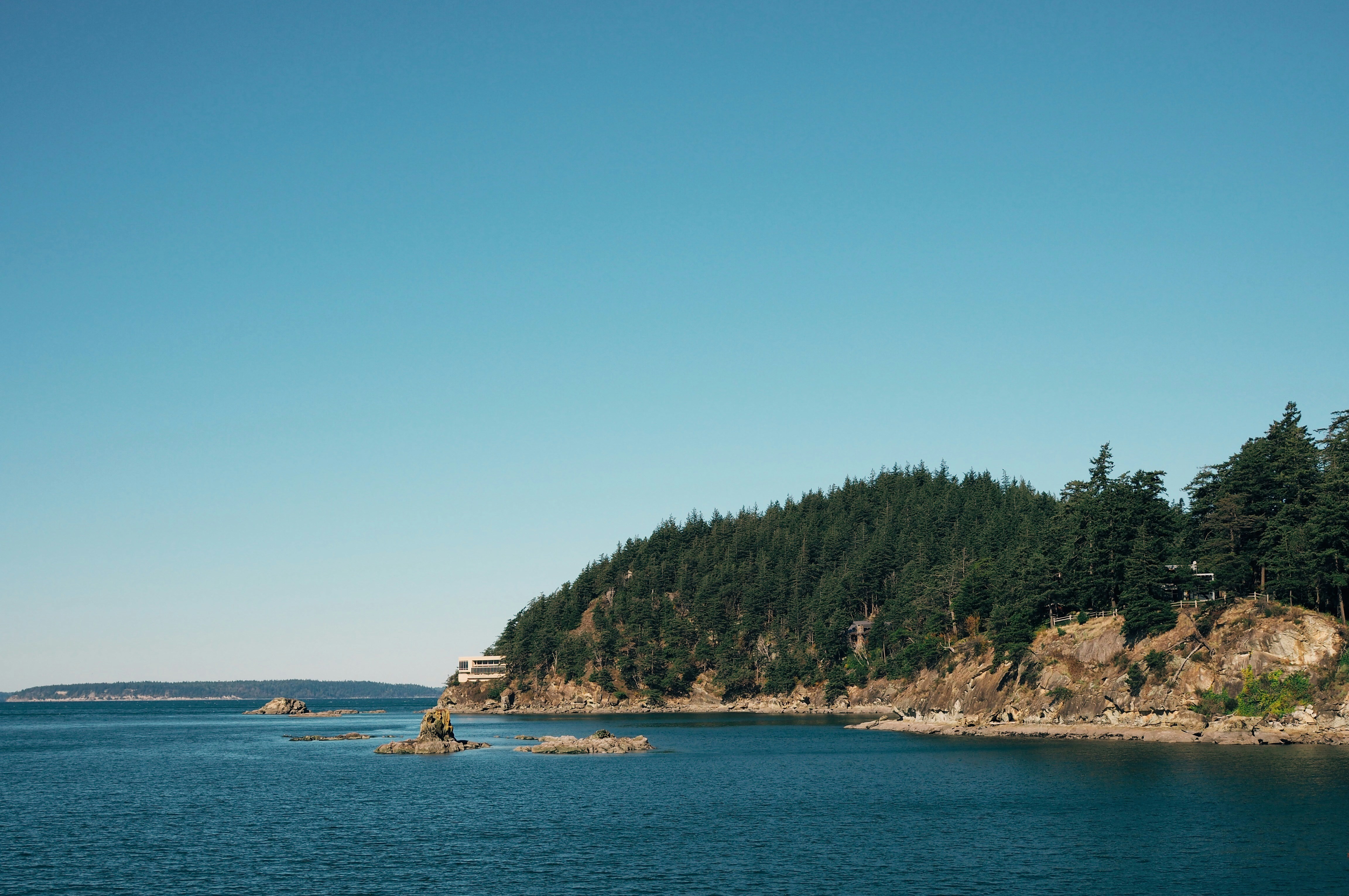 photo of house near cliff and body of water