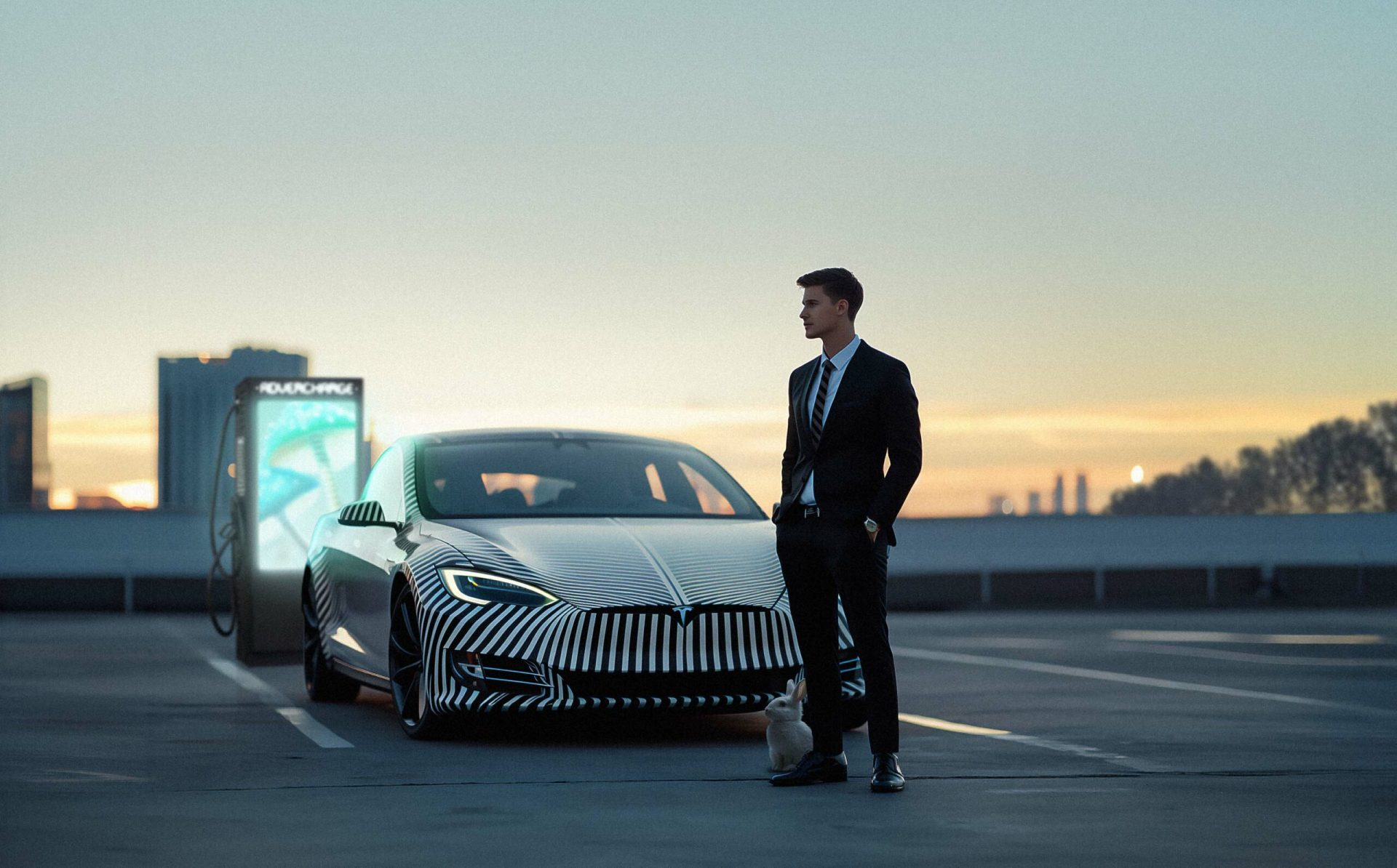 Das Bild zeigt eine moderne Ladestation für Elektrofahrzeuge in einer urbanen Umgebung bei Nacht. Im Vordergrund steht ein Mann, der auf die Ladestationen zugeht, während rechts neben ihm ein silbernes Elektroauto parkt, vermutlich um aufgeladen zu werden. Der Blick des Mannes ist auf die Ladestationen gerichtet. Drei leuchtende Werbesäulen dominieren den mittleren Bereich des Bildes. Sie tragen den Schriftzug "ADVERCHARGE" und zeigen unterschiedliche Werbeanzeigen. Zu erkennen sind eine tanzende Ballerina, ein bunter Burger und das Porträt einer Frau. Die Säulen beleuchten den Boden mit einem auffälligen schwarz-weißen Zickzackmuster. Im Hintergrund ist die Skyline einer Stadt mit beleuchteten Hochhäusern zu sehen, was die urbane Lage der Ladestation unterstreicht. Die gesamte Szene wirkt futuristisch und technologisch fortschrittlich, wobei die Kombination von Elektromobilität und digitaler Werbung im Vordergrund steht.