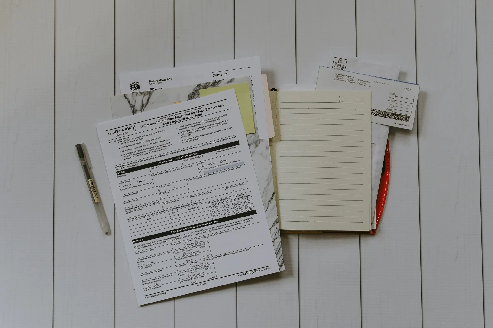 Documents and notepad used to review key clauses in a vehicle rental or lease agreement