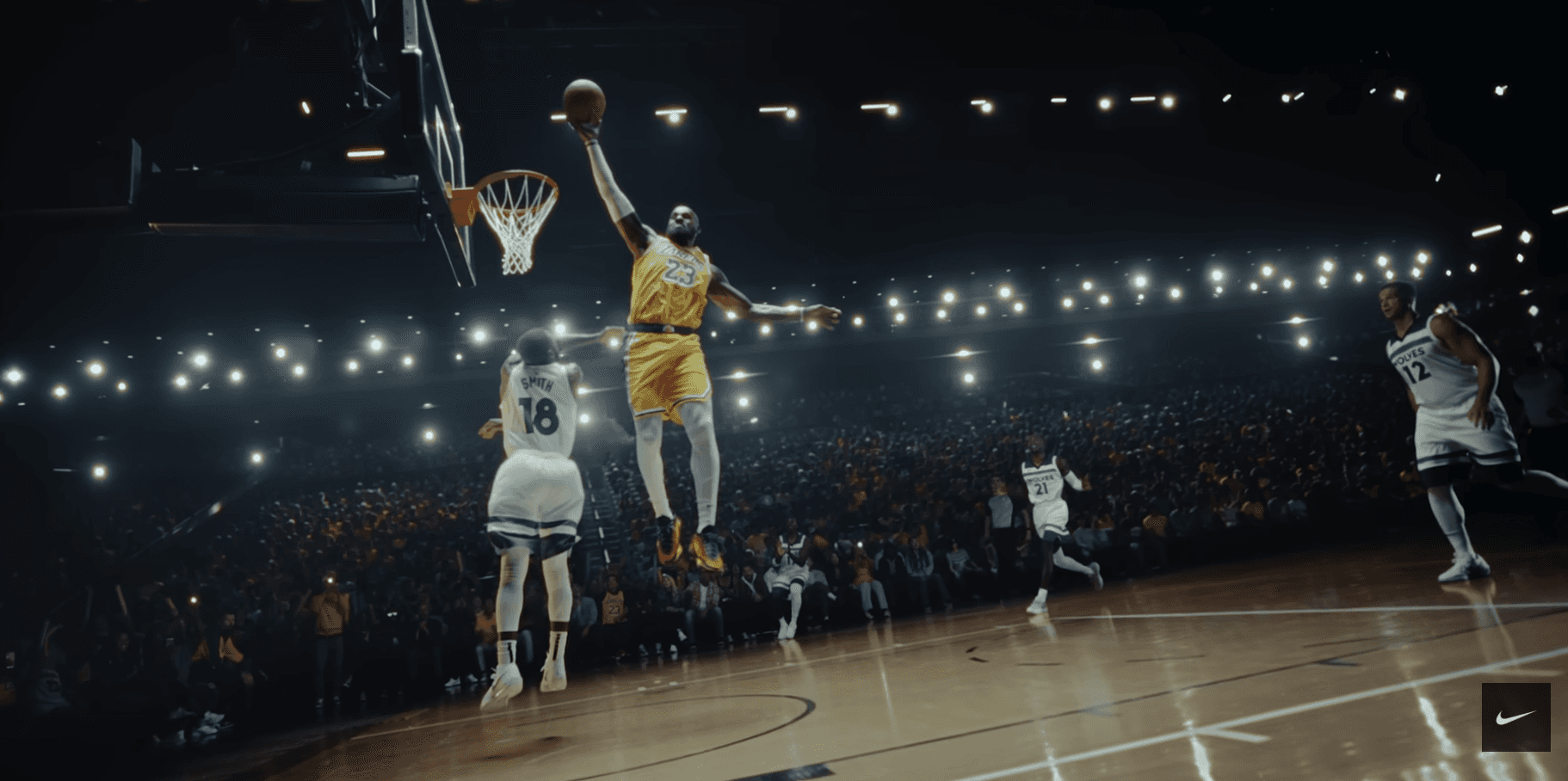 Lebron James jumping mid air to throw the basket ball in the basket in nike jersey among white jersey players