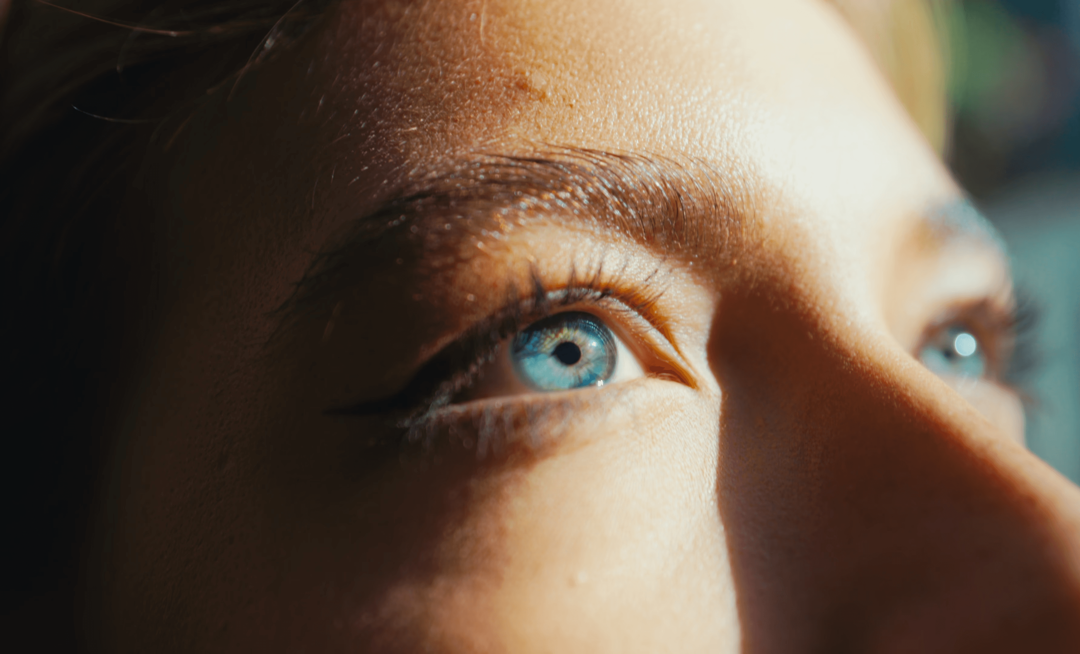 Close-up of a woman looking into the sky. Blue Eye in the middle