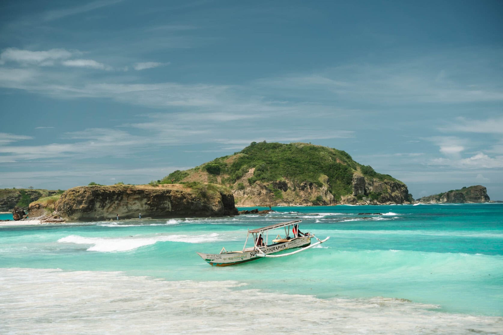 a group of people carrying surfboards on top of a beach