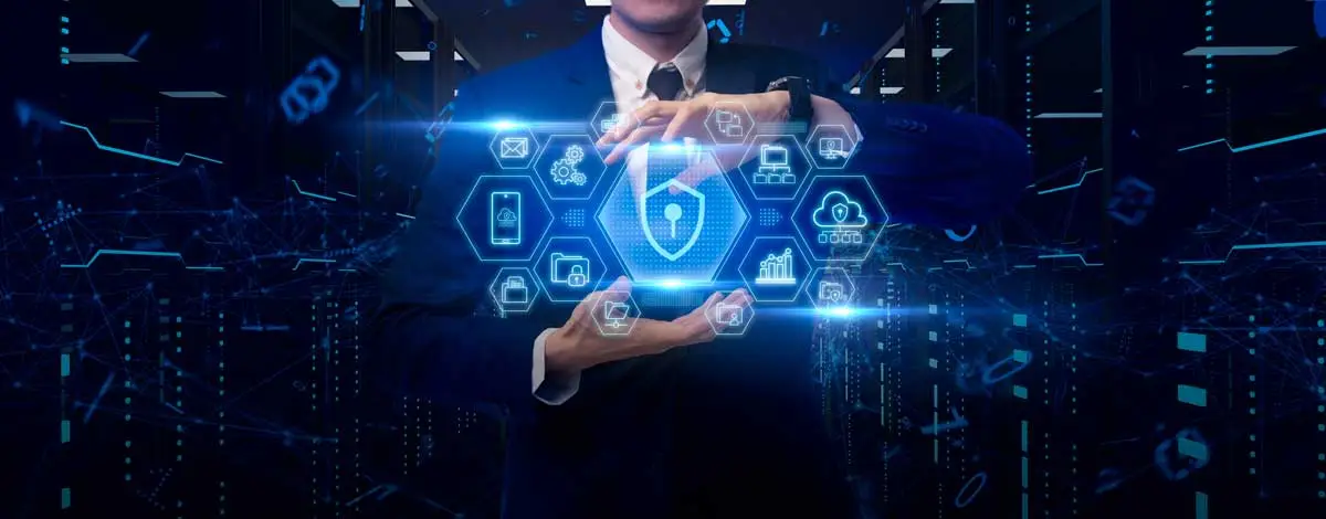 A person walks in front of large stone arches with dark doors, flanked by tall columns, in a historic building.