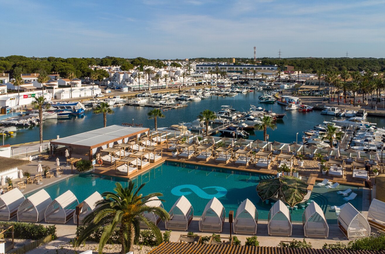 Luxuriöser Yachthafen mit Pool und Liegen, Palmen, weiße Gebäude