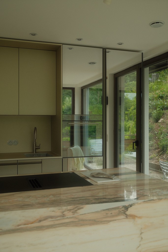Naturstein Küche im Bodensee von Faber & Söhne Küchenmanufaktur mit Holzlamellen Front