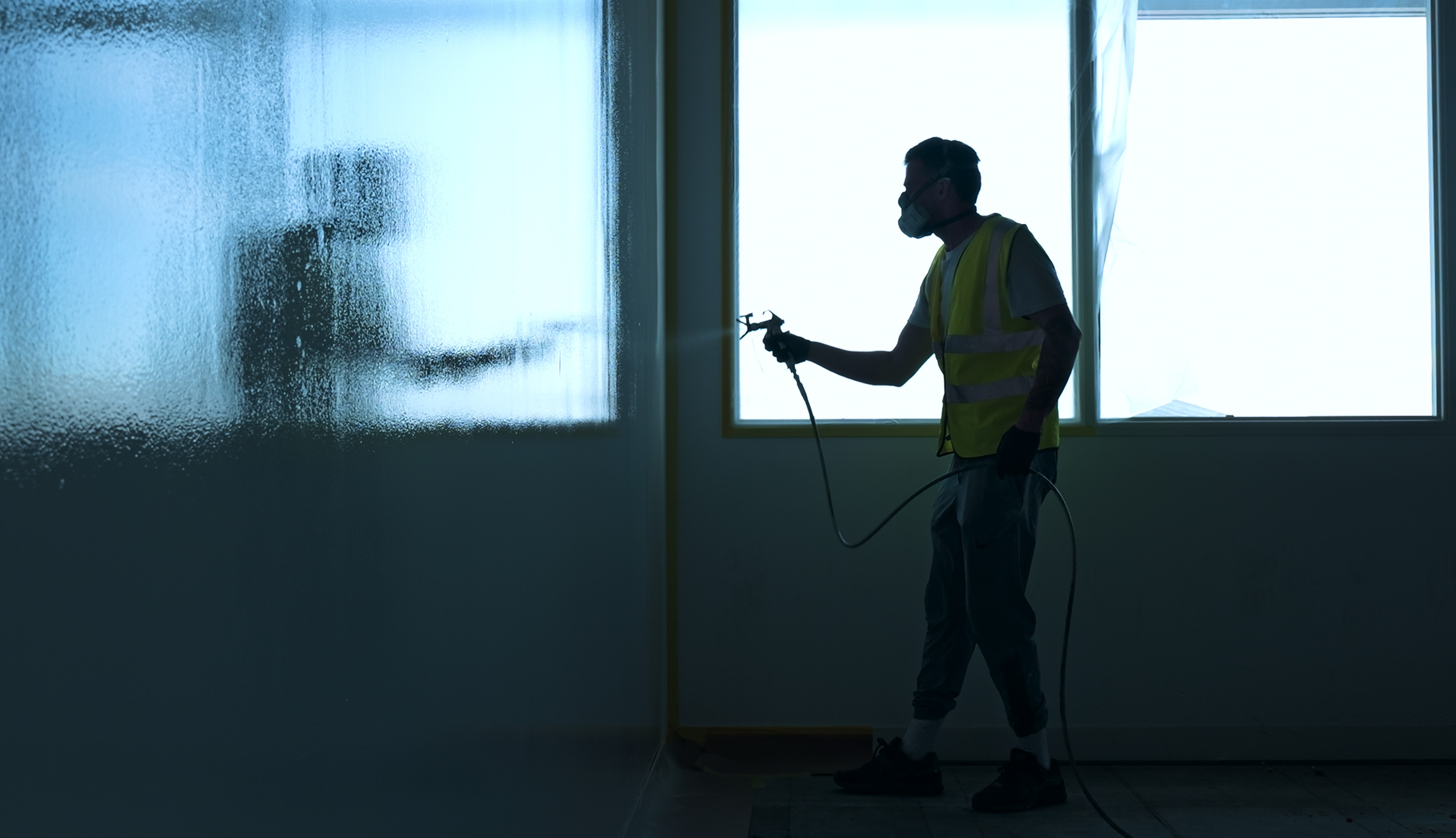 Painter and Decorator from Barry Turner and Son, spray painting a large wall