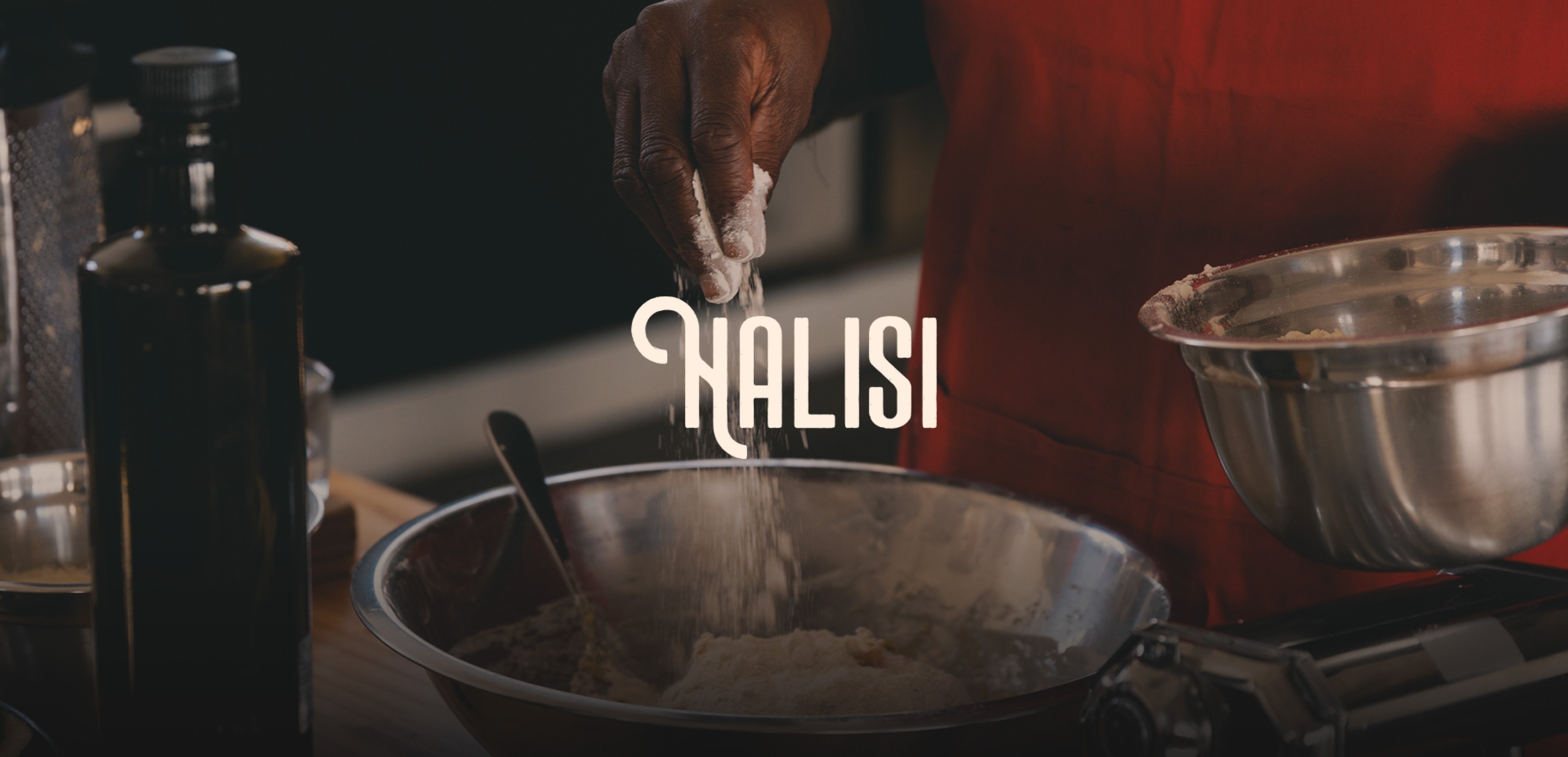 Close up of an African woman's hand, adding more flour to her metalic bowl