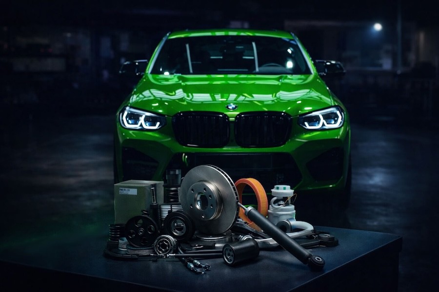 Green car with auto parts in front