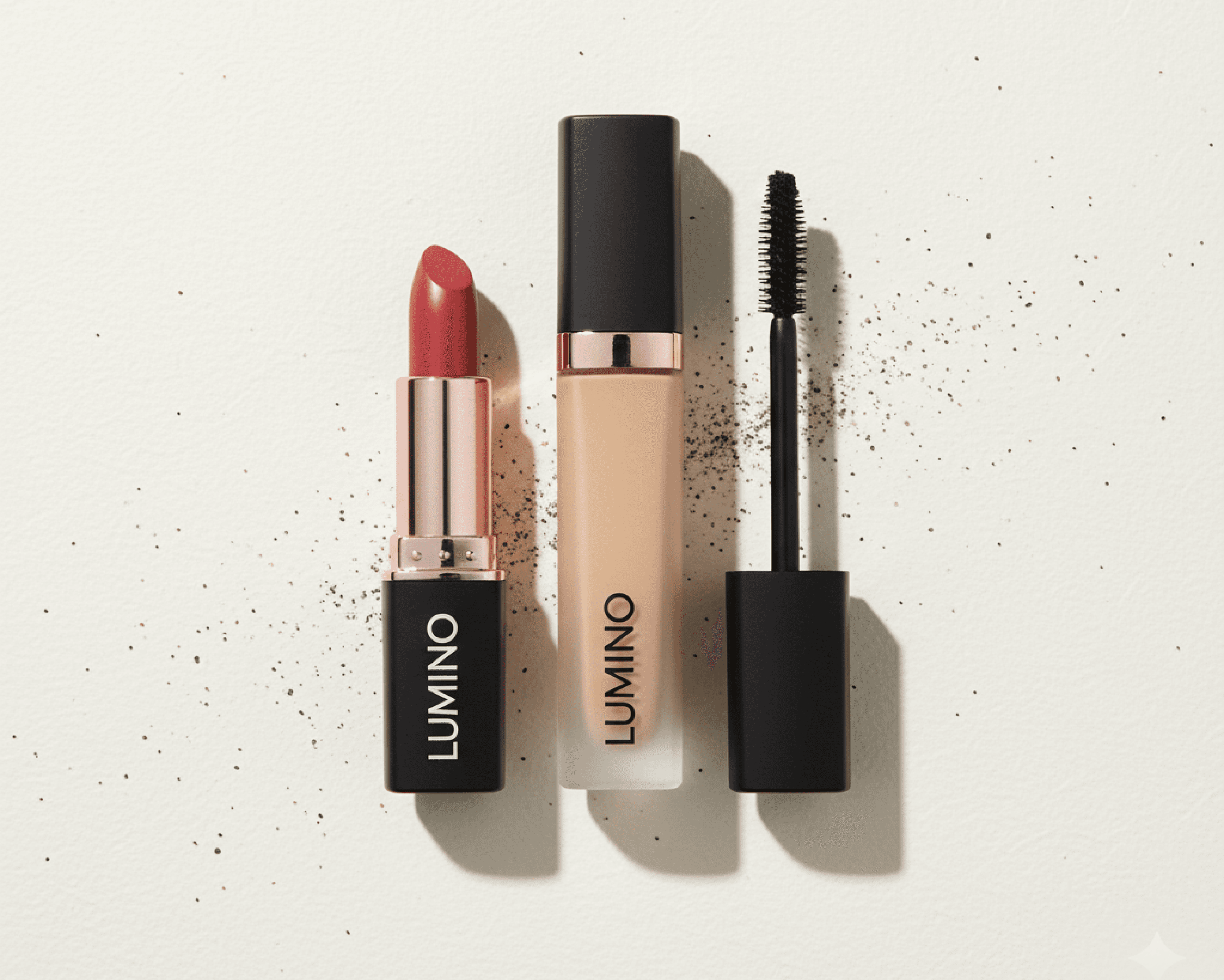 Red lipstick, beige foundation, and black mascara labeled 'LUMINO