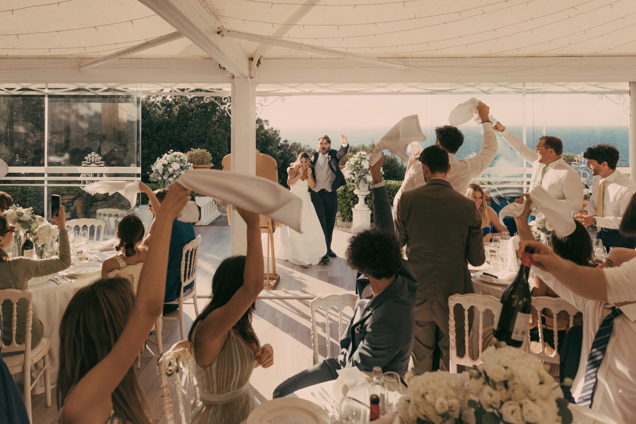Lancio del riso al ricevimento di matrimonio a Bolgheri, ospiti festeggiano gli sposi sotto la tensostruttura