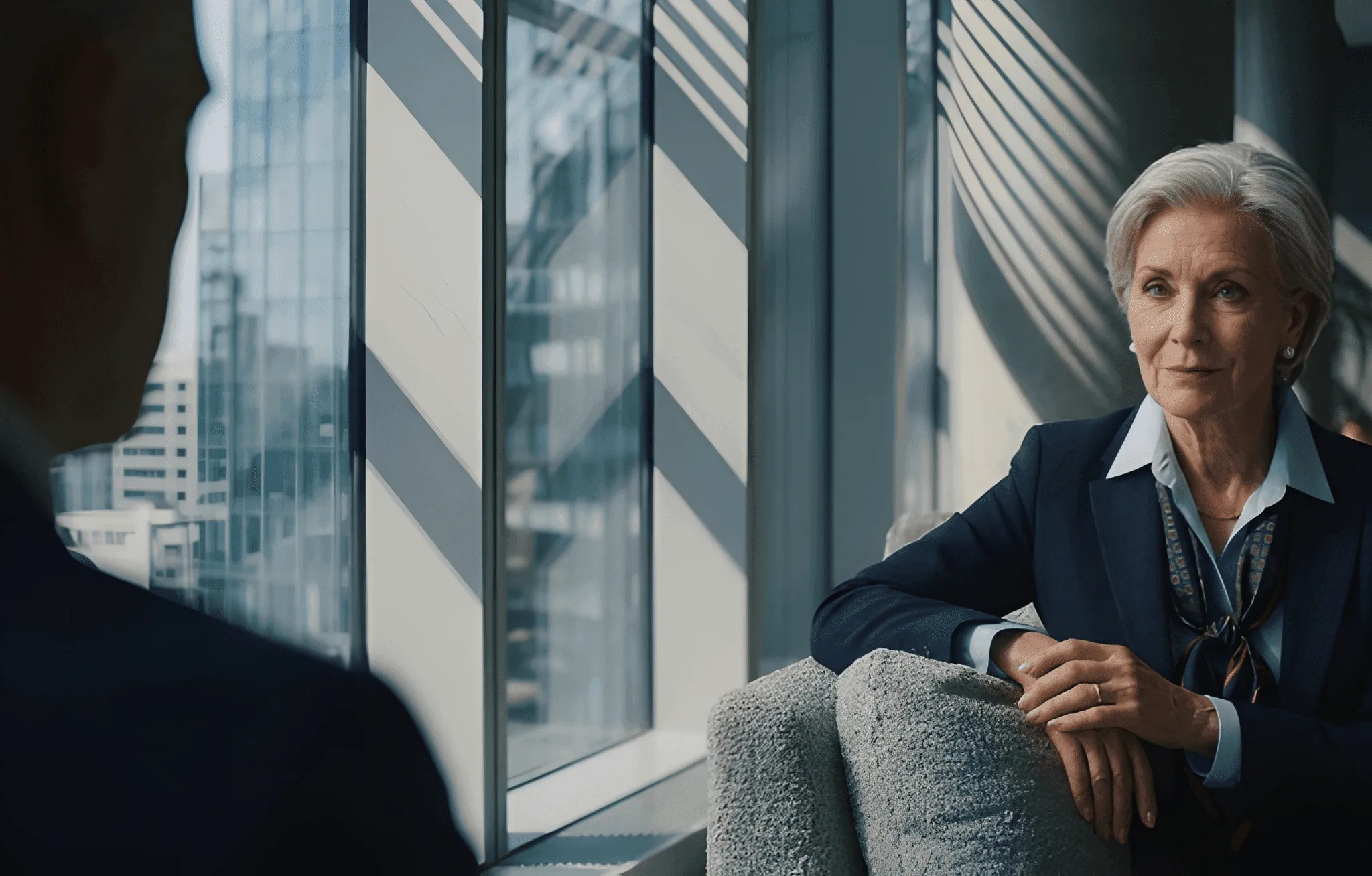 Grand stone building with glowing windows under a deep blue twilight. Dramatic lighting casts a mysterious, elegant ambiance. Surrounded by shadowy trees.