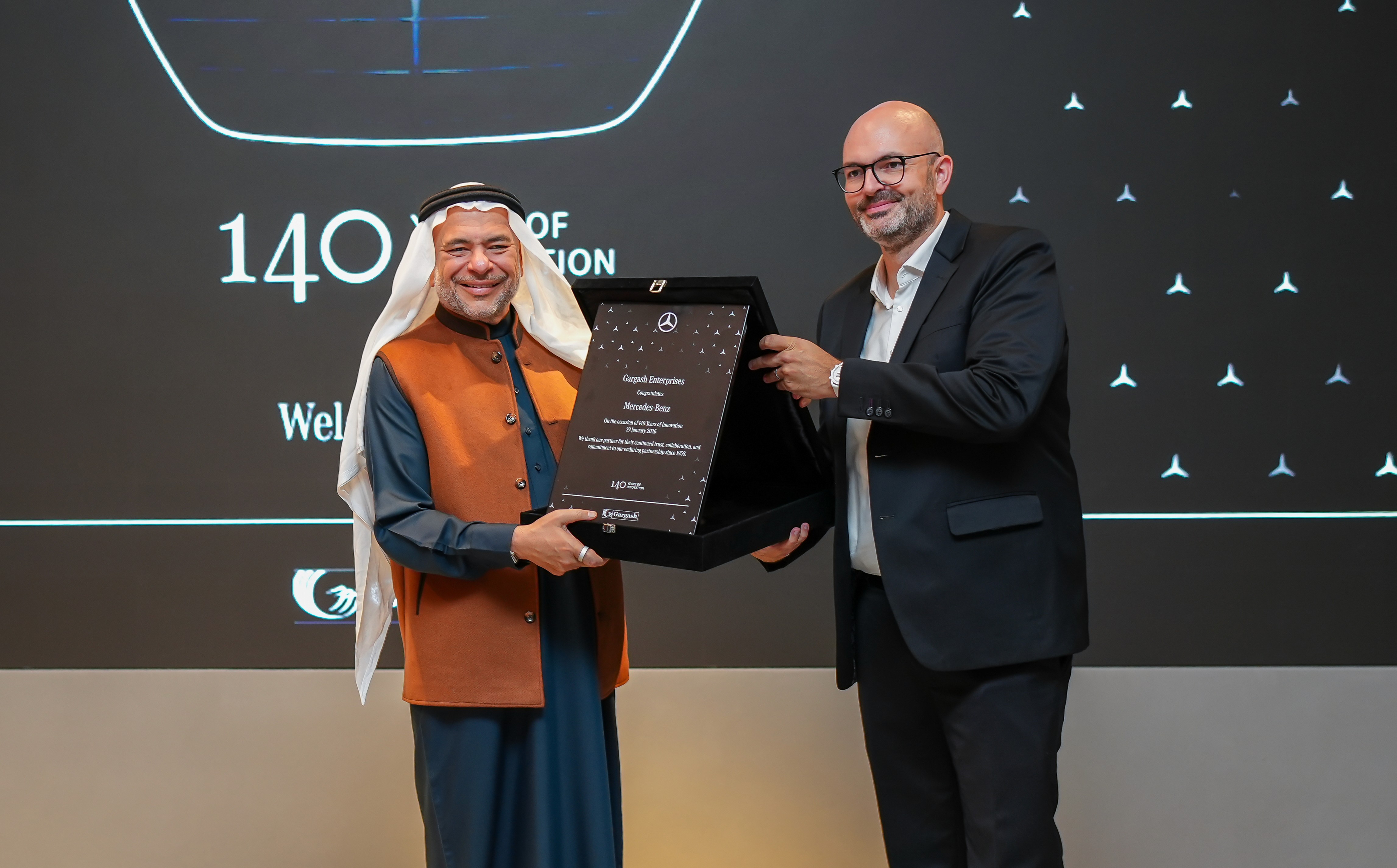 Female scientist wearing a white coat and gloves examines a sample slide in a modern laboratory setting.